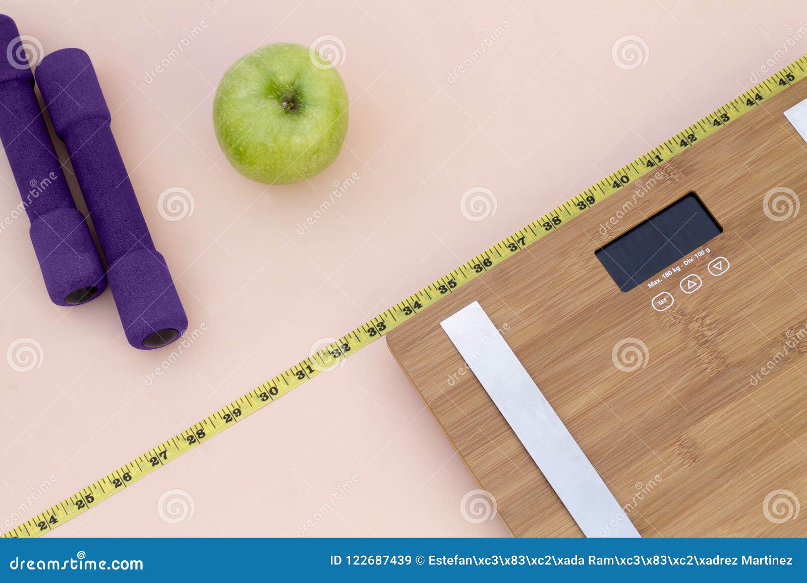 still life photography with a green apple, weight tape measure and a scale