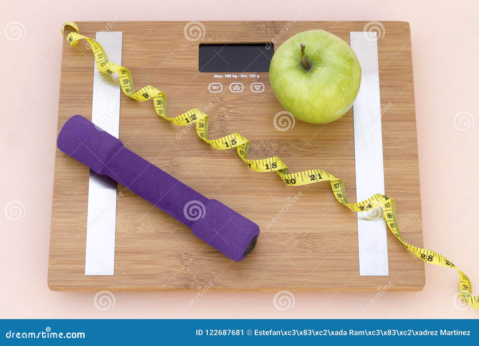 still life photography with a green apple, weight tape measure and a scale