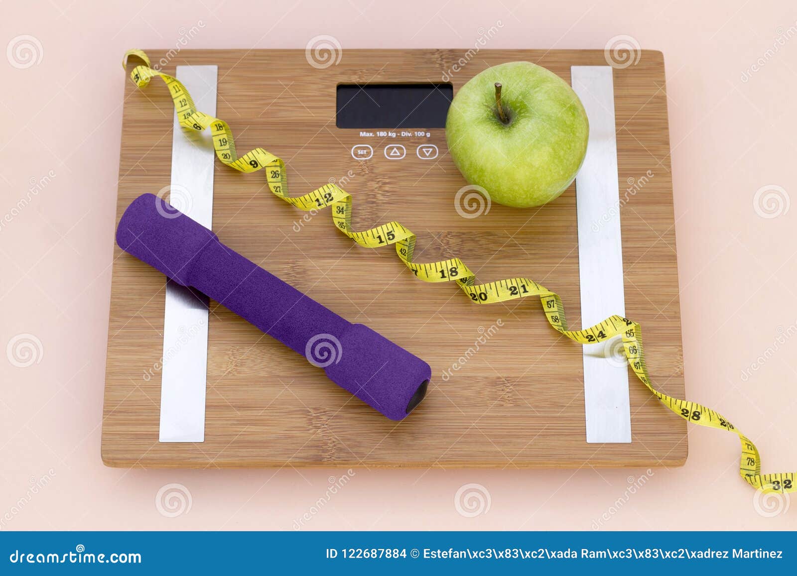 still life photography with a green apple, weight tape measure and a scale