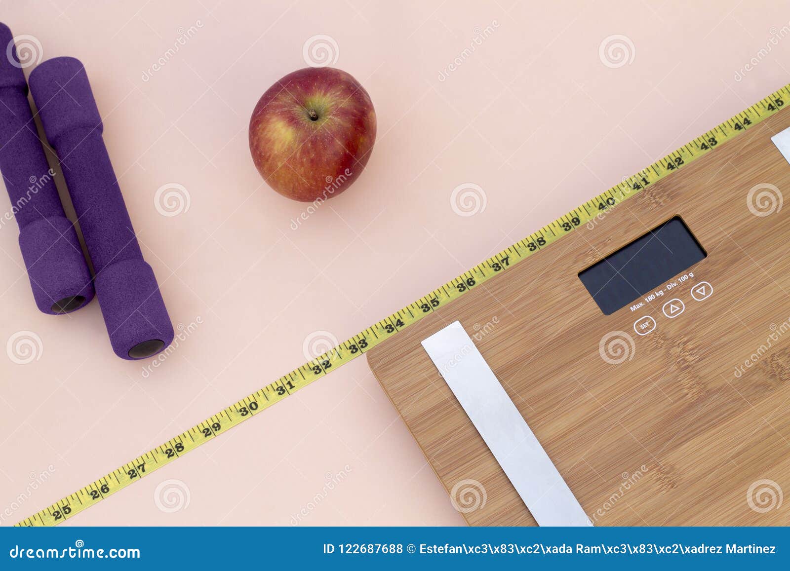 still life photography with a red apple, weight tape measure and a scale