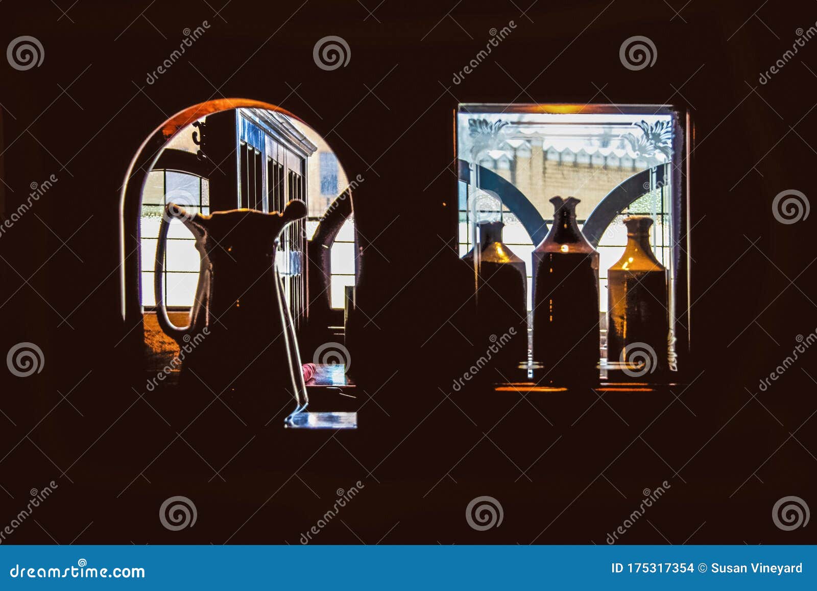 stilllife view of windows through cubbies with etched glass in a dark pub with tables and a castle viewed through distant windows