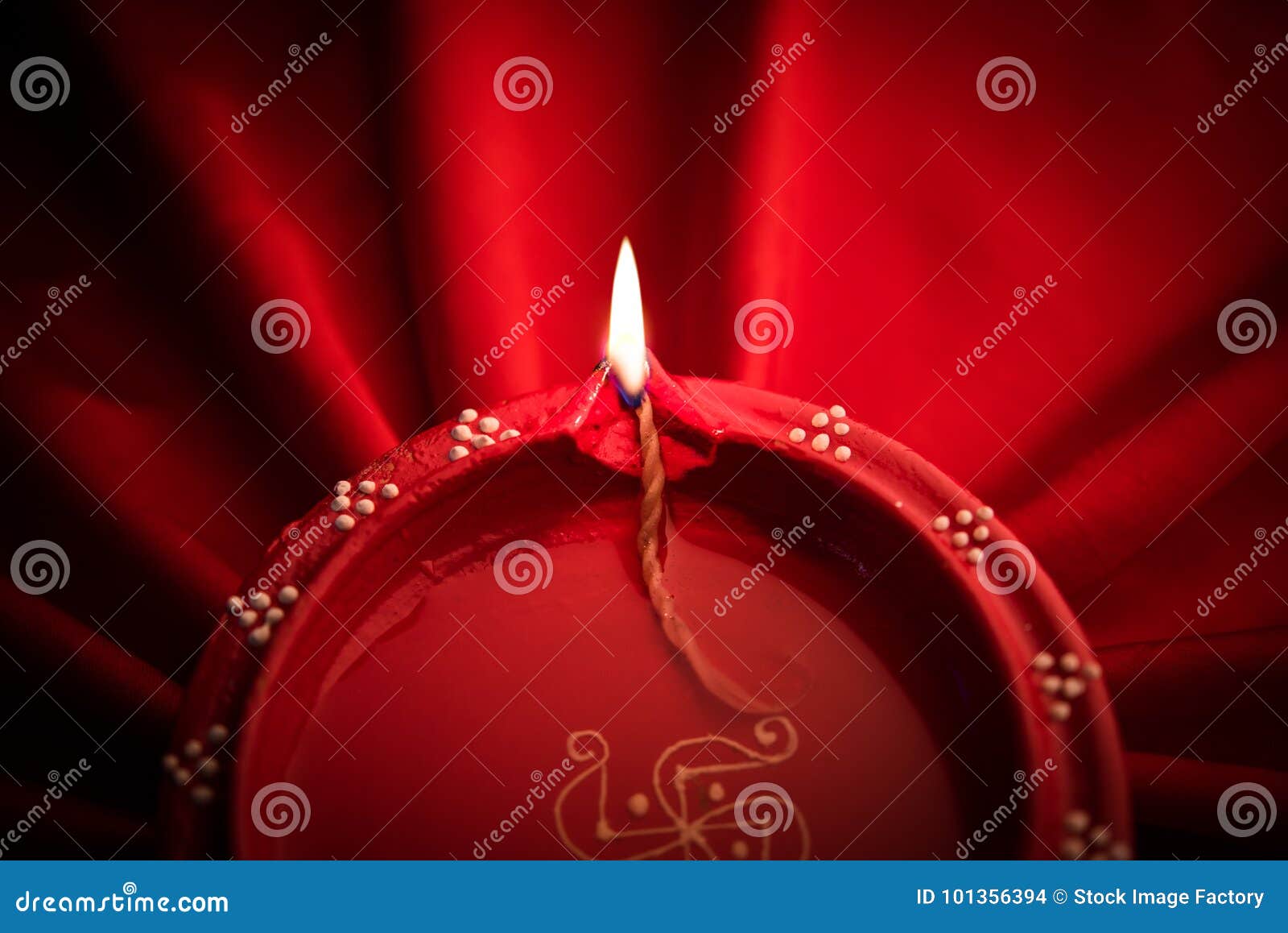 stock photo of diwali diya or clay lamp over silk or satin cloth, happy diwali