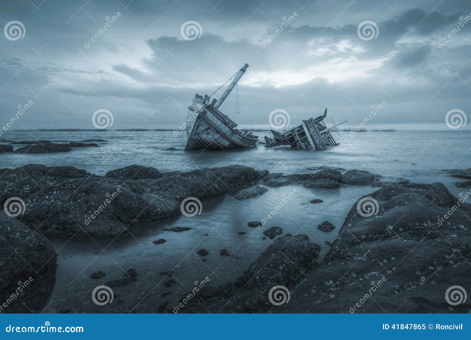 Stocznie. Antyczni shipwrecks w morzu z zmierzchu tła błękitnym kolorem tonują