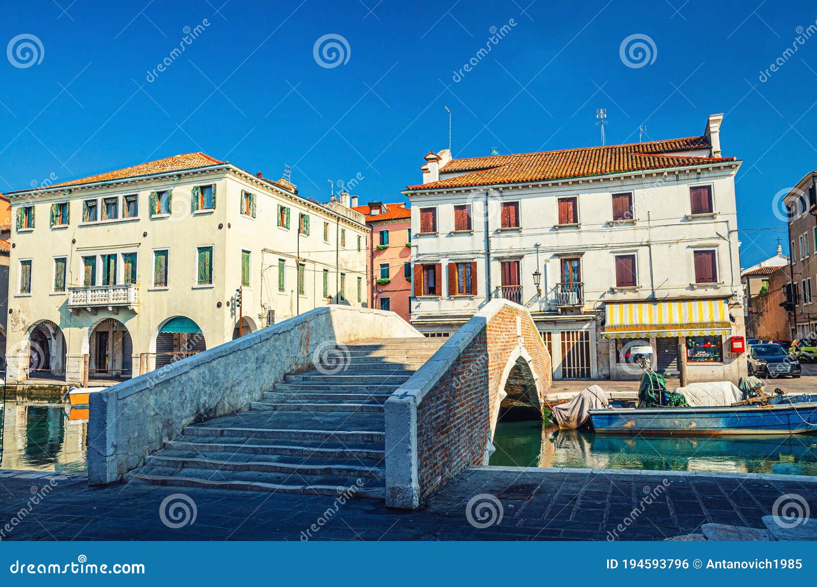 stone brick bridge ponte pescheria across vena water canal and old buildings in historical centre of chioggia