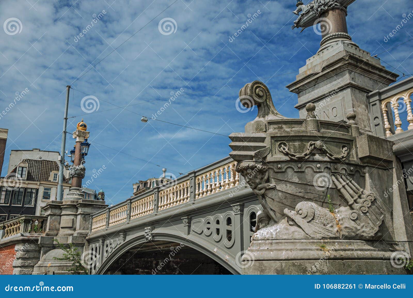 Stone Bridge Over Canal by Sculpture of Ship`s Bow and Elegant Light Post in Amsterdam. Stock Image - Image of finery, blue: