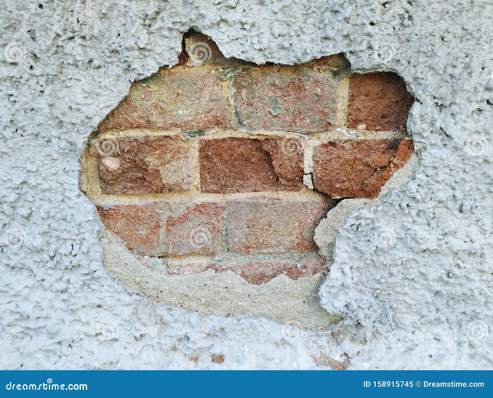 A Hole in the Wall. Chipped Piece of Plaster. Under the Rough Surface