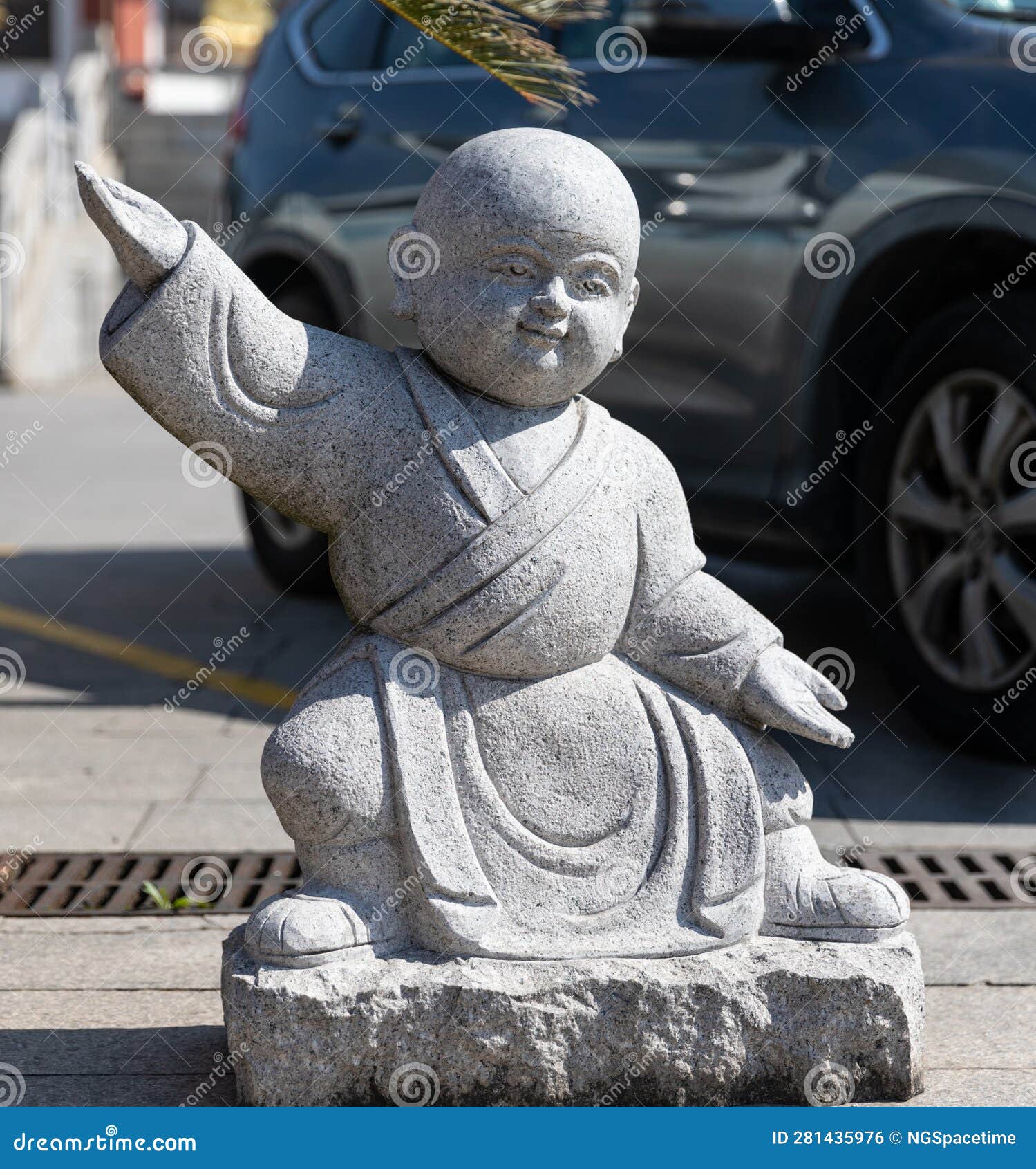 stone figurine of little monk practicing kongfu in courtyard of qibao temple