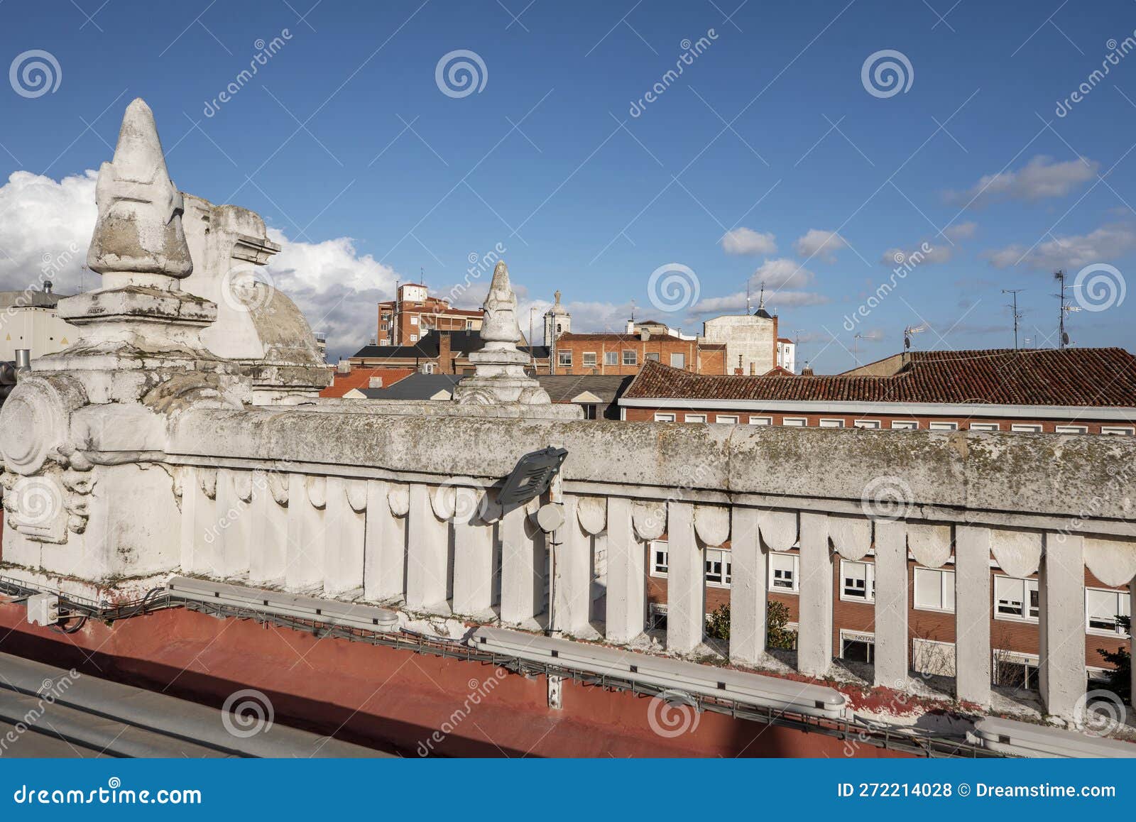 stone railing on the roof of a vintage building overlooking the city