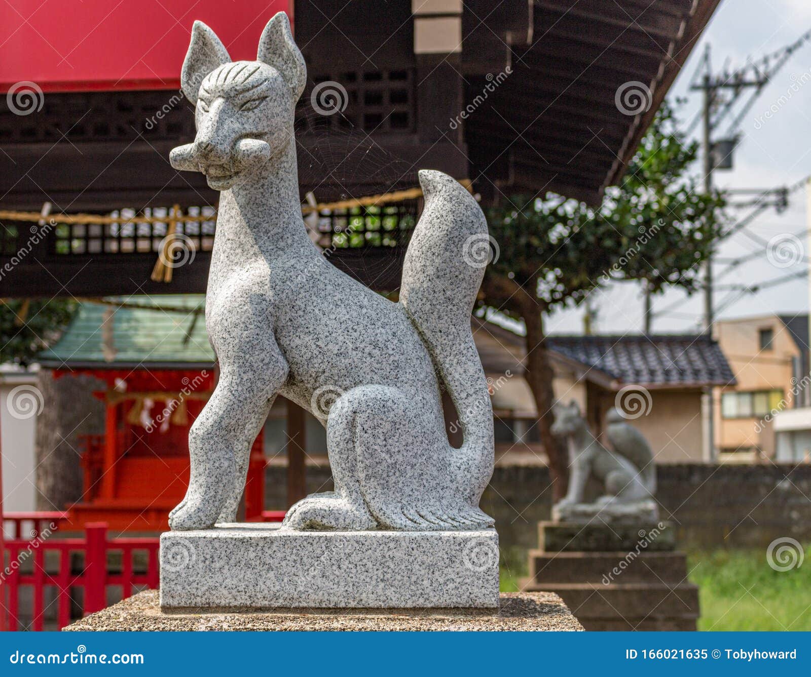 stone statue of fox, or kitsune, at nomachiinari shinto shrine in kanazawa, japan.