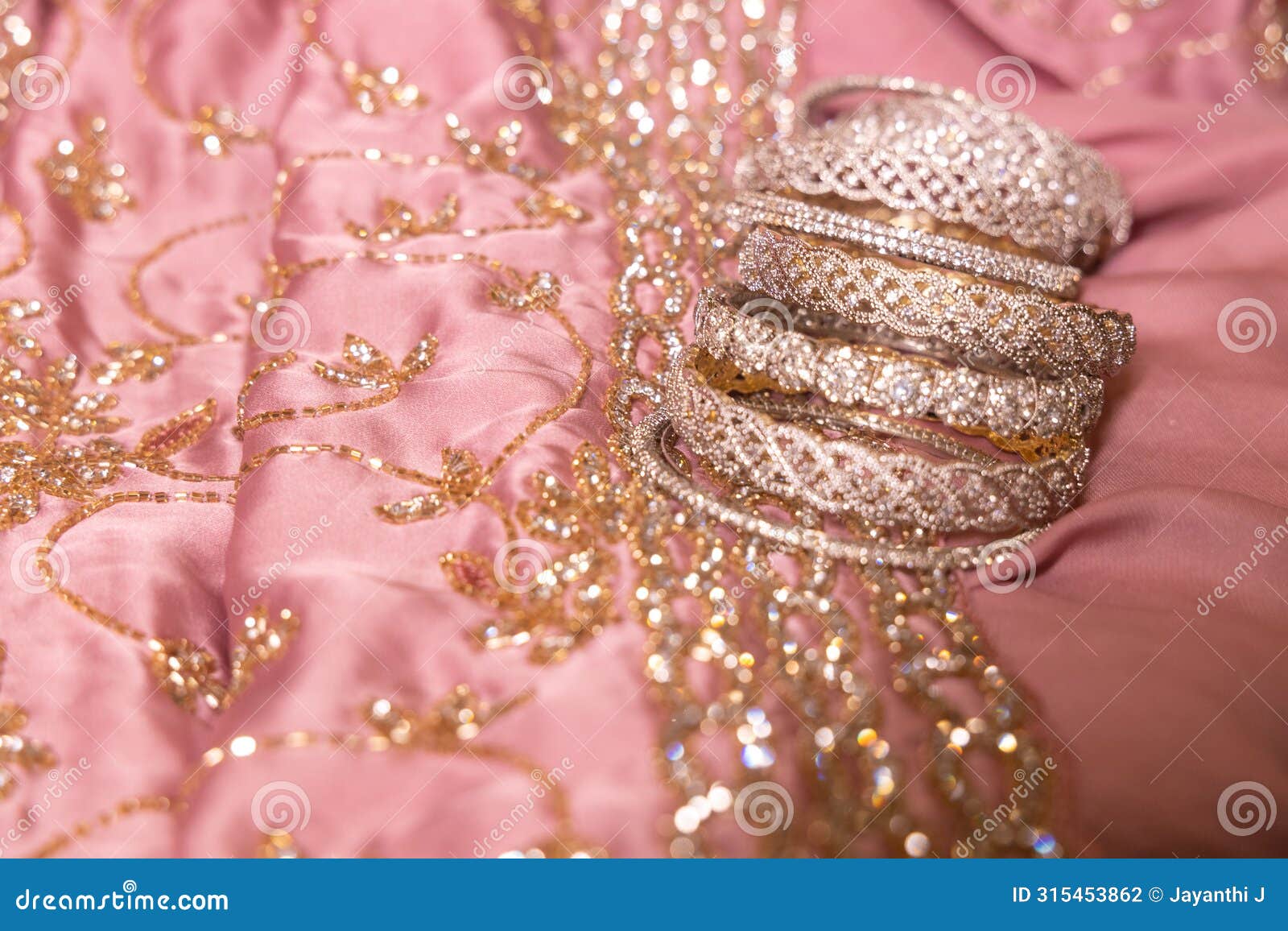 stone studded intricate bangles spread on yellow marigold flowers in a low lit area