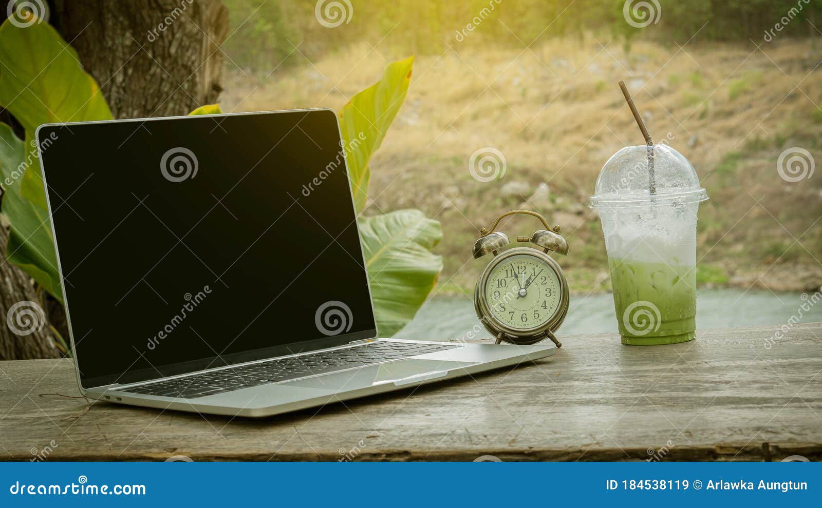Stop Drinking Iced Green Tea with a Clock and Computer on the Table at
