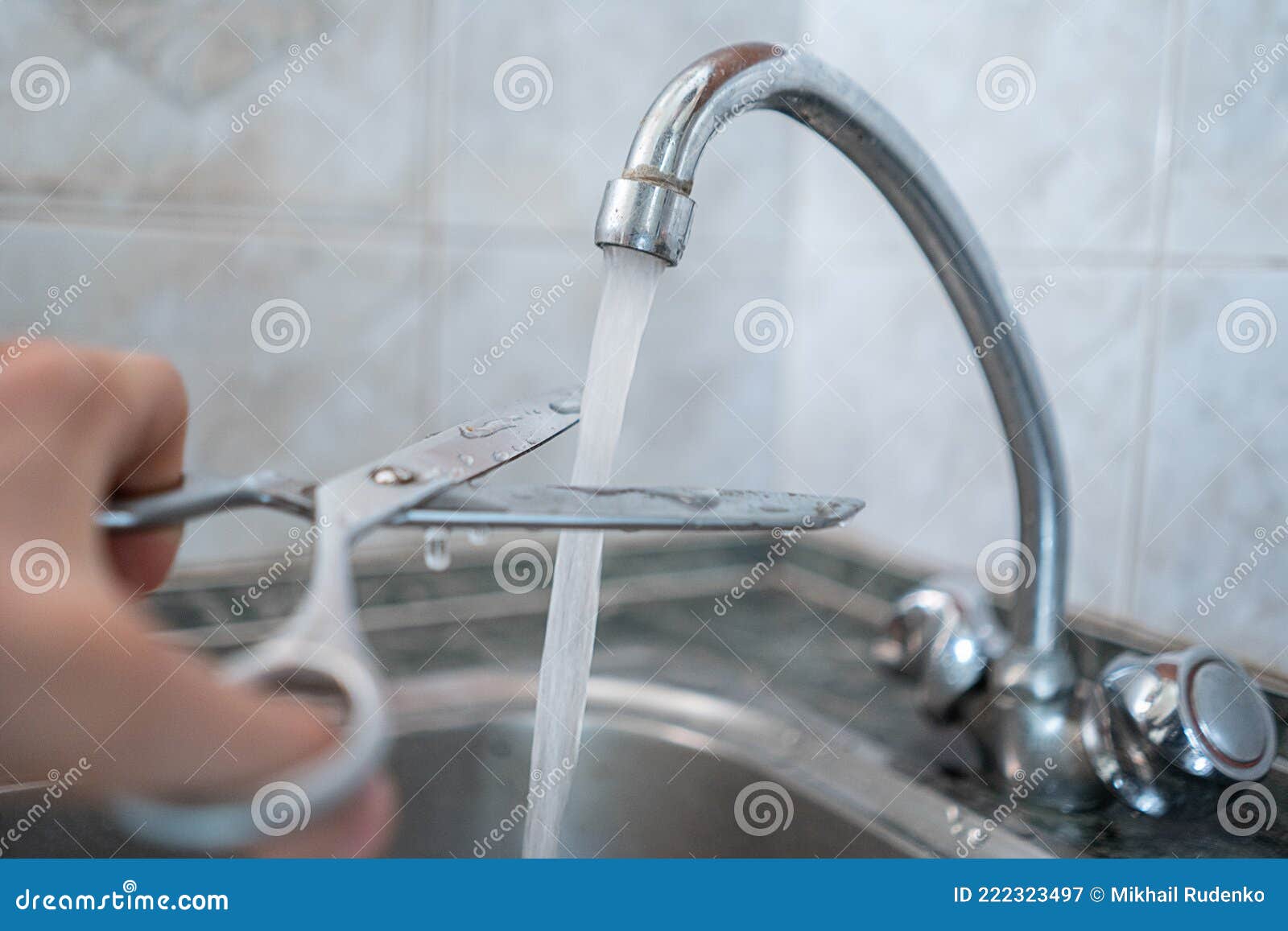 Stop Wasting the Pure Water, Hand with Scissors Cut the Water Stream