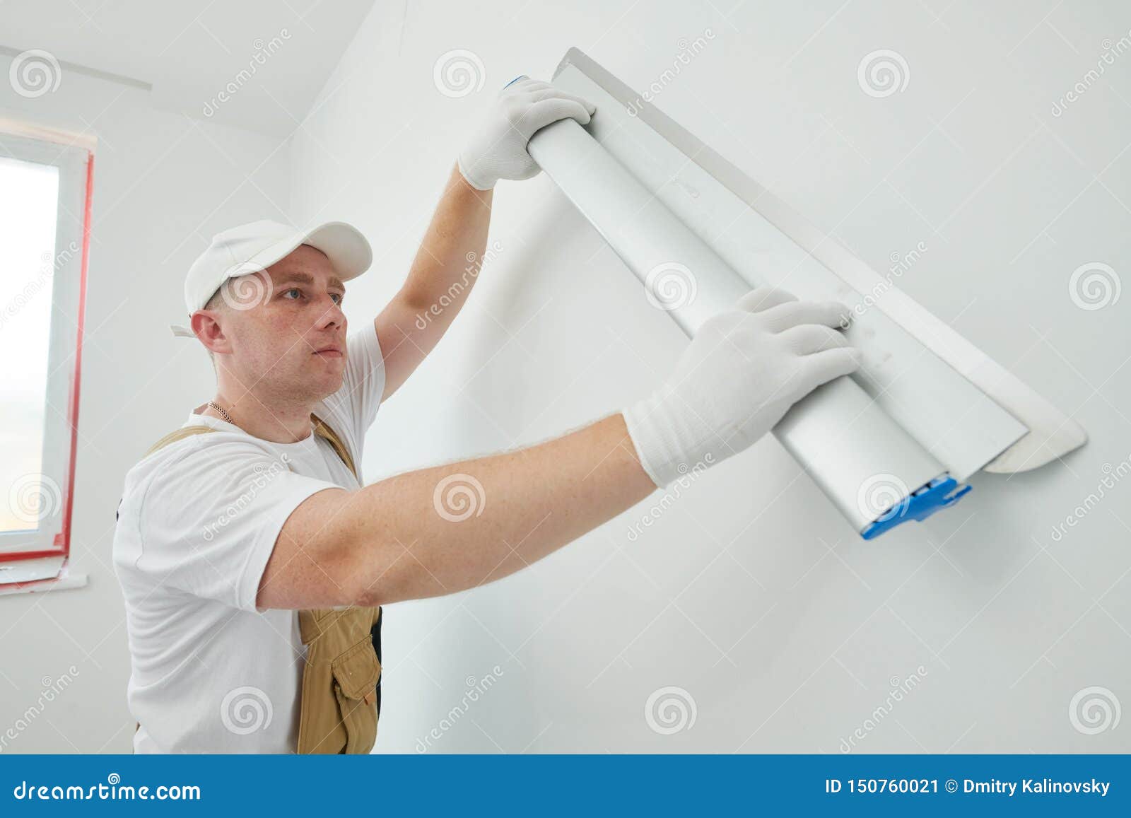 painter with putty knife. plasterer smoothing wall surface at home renewal