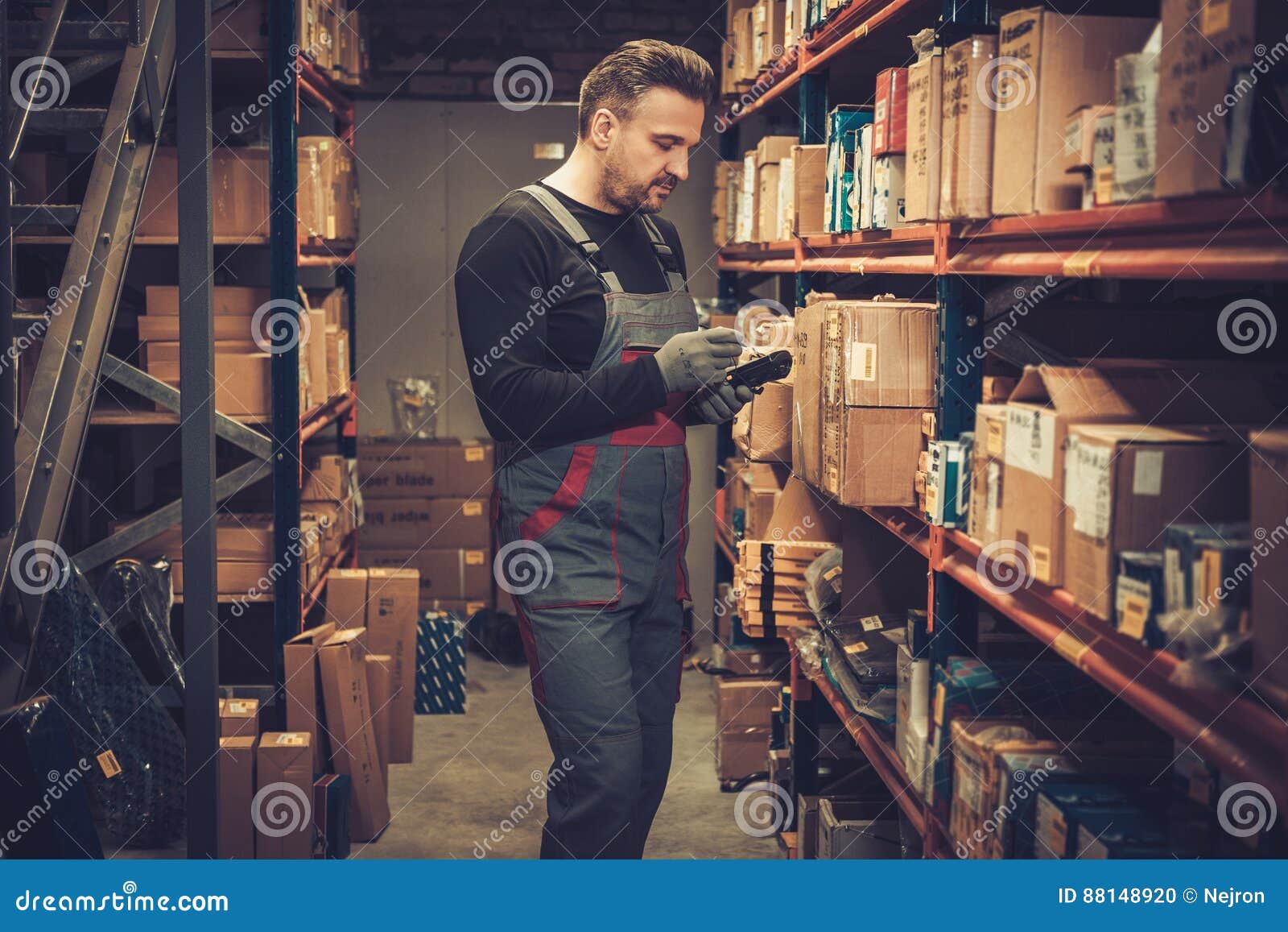 storekeeper with handheld barcode scanner working in a warehouse