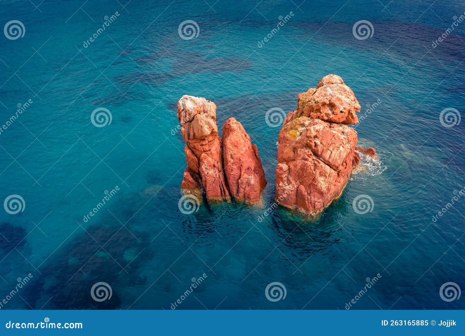 straight down view from flying drone of red rocks gli scogli rossi - faraglioni on the di cea beach.