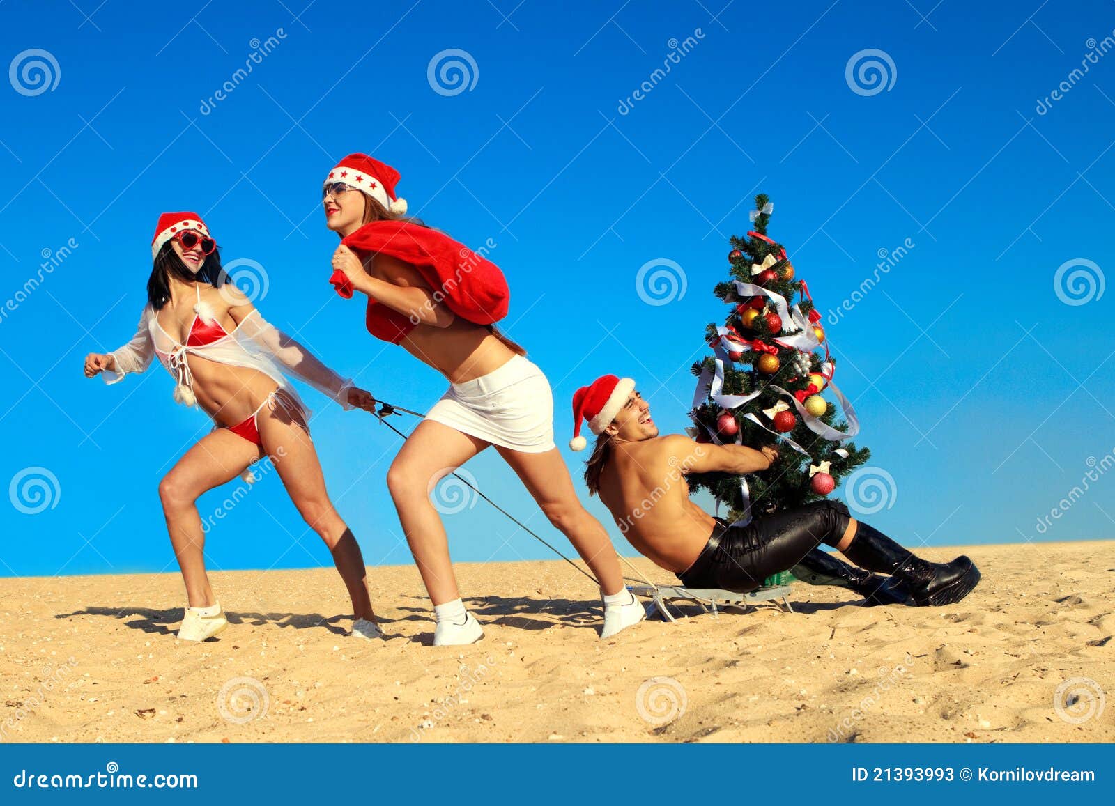 Strand som drar santa sexiga santas. Sätta på land julbegreppsgyckel som drar tropisk vinter två santa santas för den sexiga sledtreen