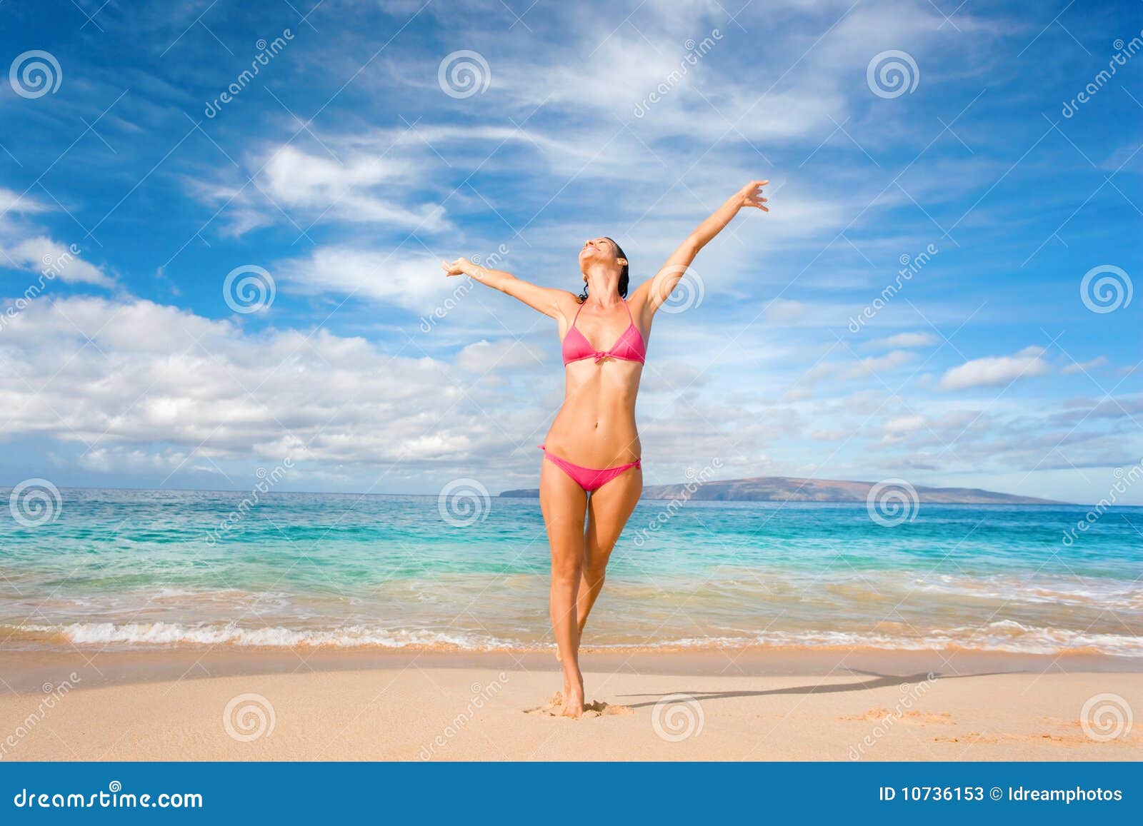 Strandspiel. Schöne exotische Frau im rosafarbenen Bikini auf Strand