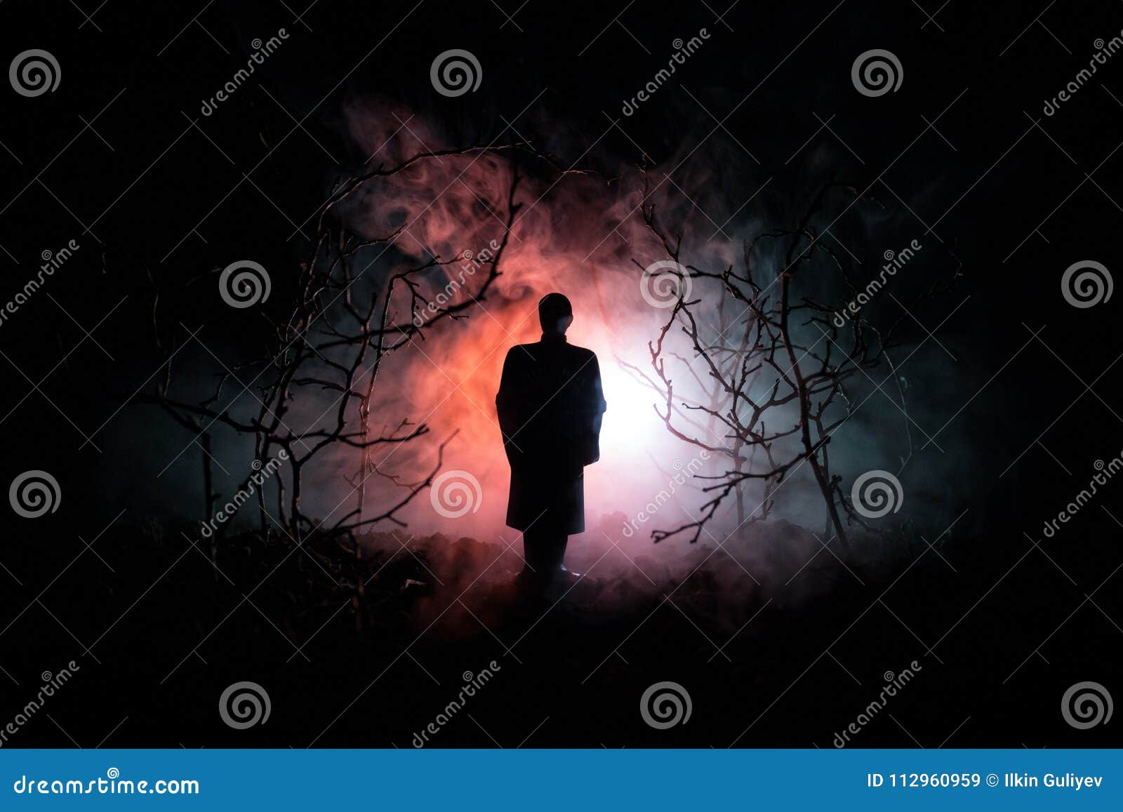 strange silhouette in a dark spooky forest at night, mystical landscape surreal lights with creepy man. toned