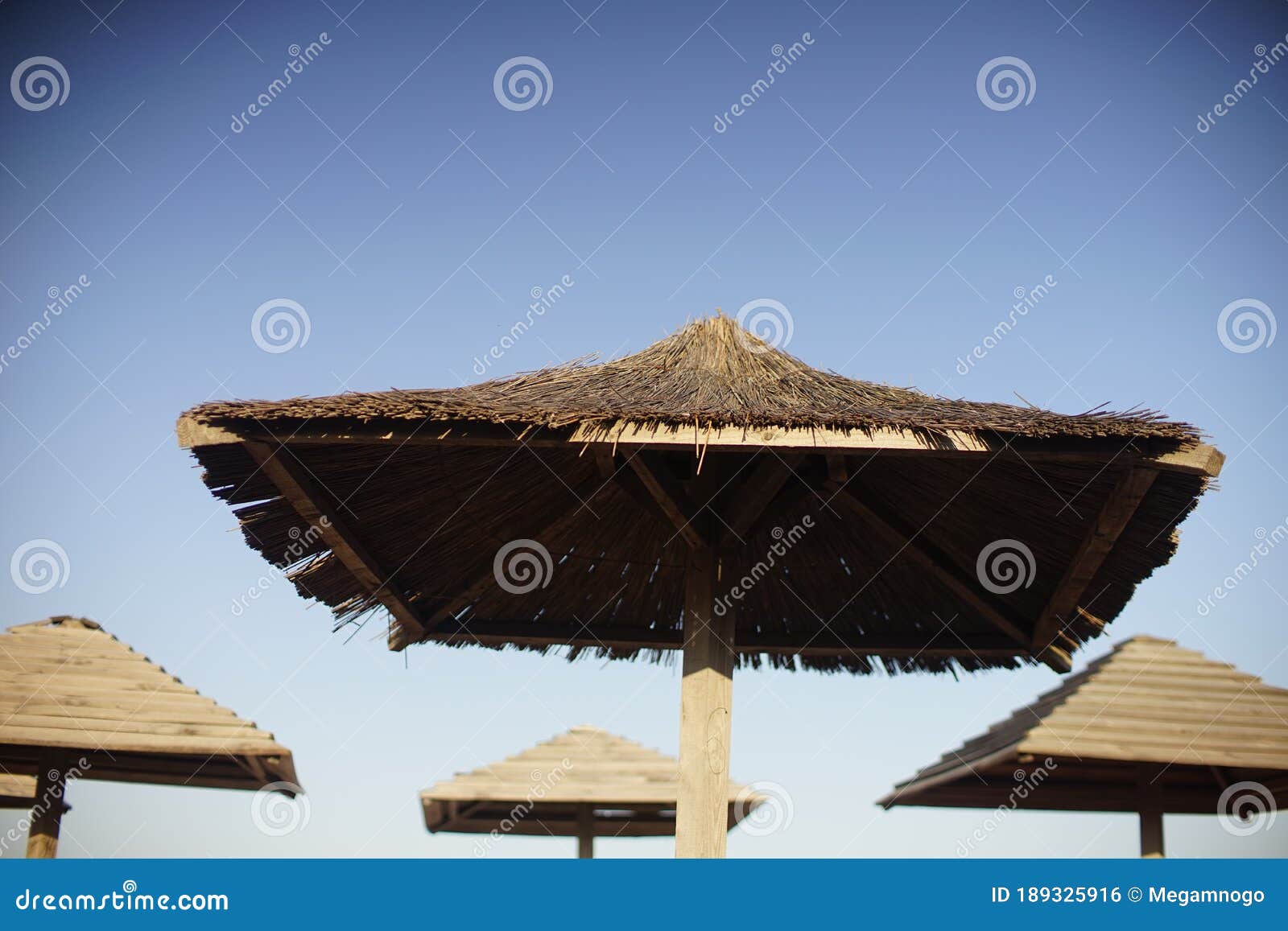Straw Canopies on the Beach Against the Blue Sky Stock Photo Image of
