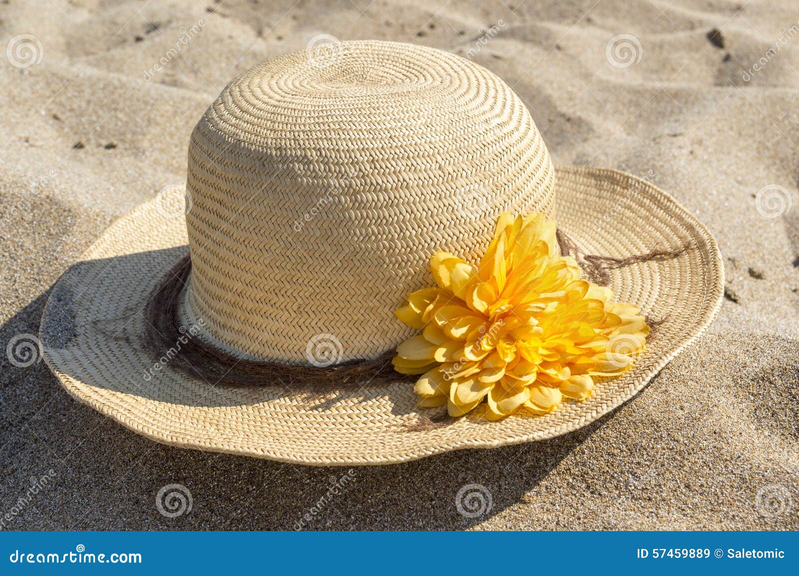 Straw Hat Decorated with Flower Placed on the Sandy Beach Stock Image