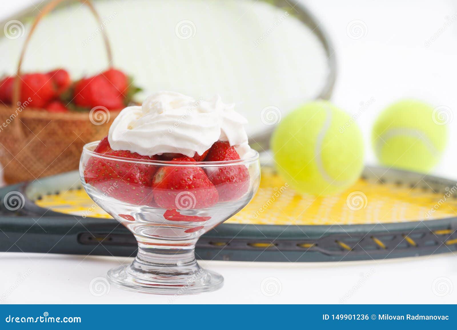 strawberries with whipped cream and  tennis equipment on wimbledon tournament.
