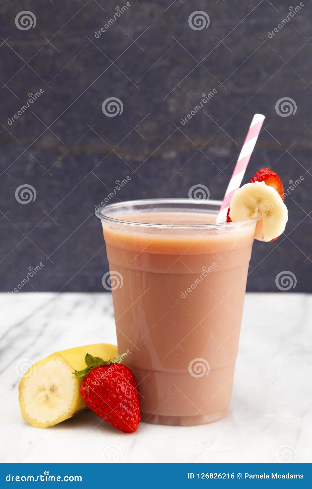 Banana, strawberry and chocolate milkshake in plastic cup with