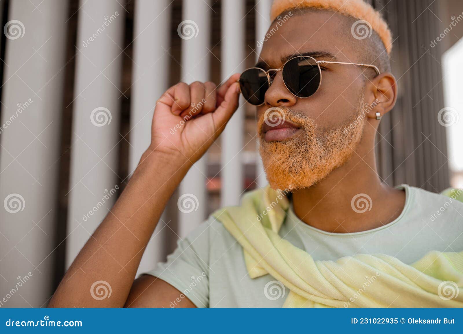 a dark-skinned model with a dyed beard posing for the camera