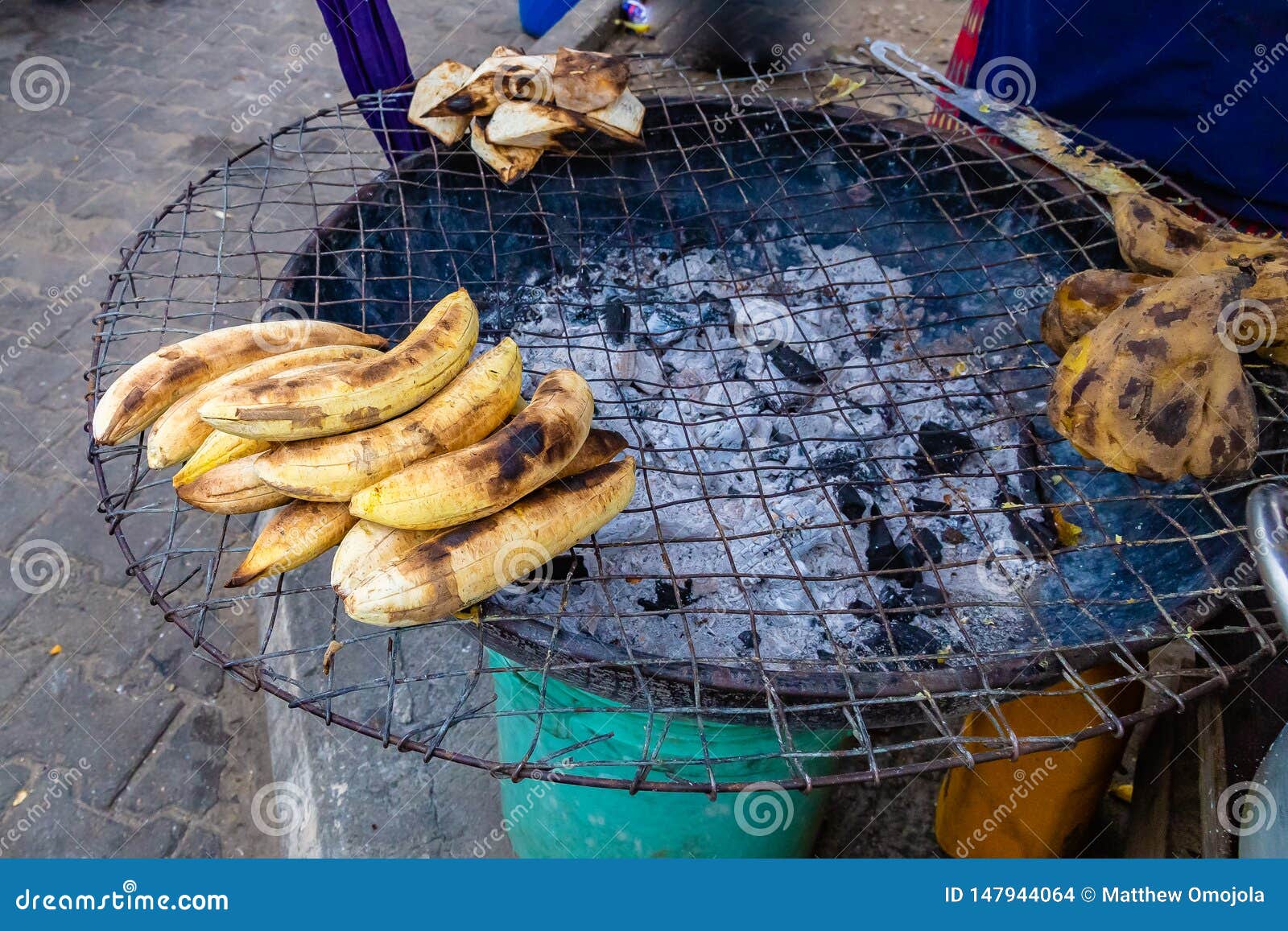 street foods in lagos nigeria; roadside charcoal grill with roasted  yam, plantain and sweet potato