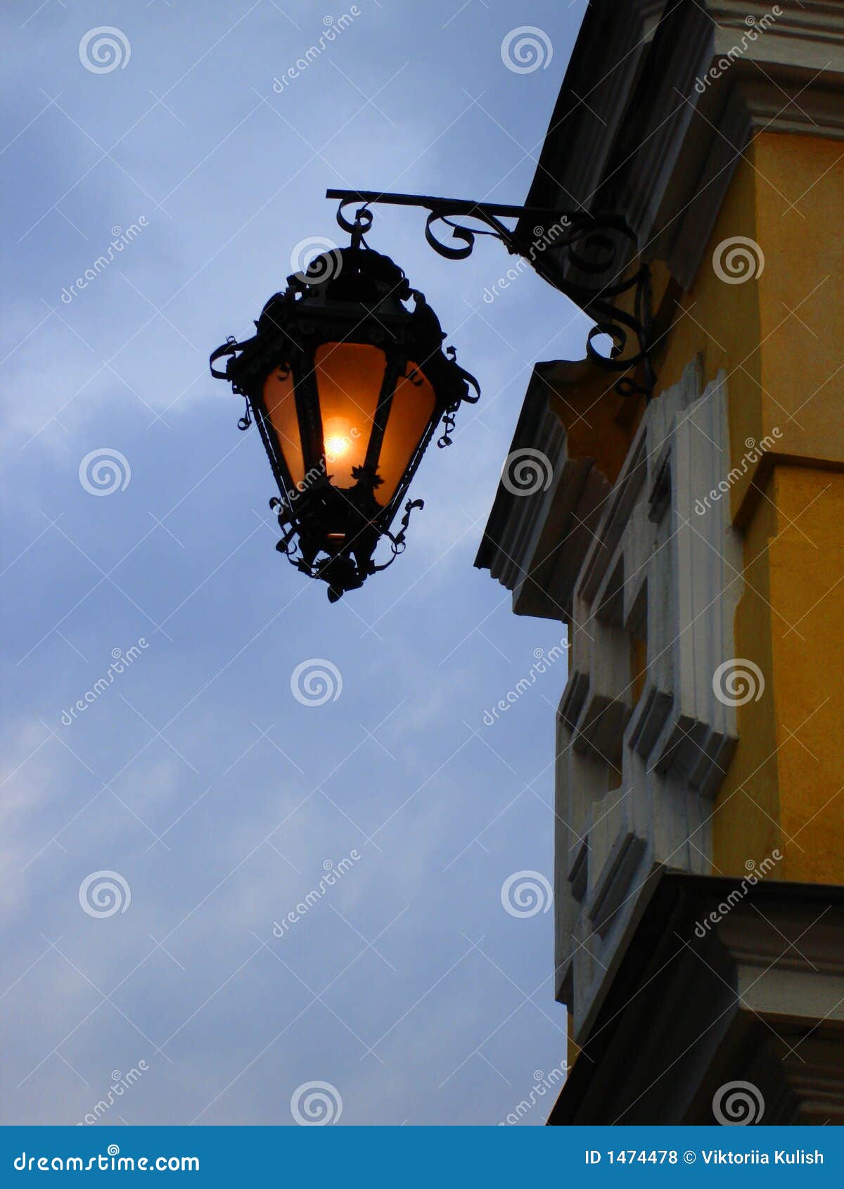 Street lamp on a yellow wall in the evening