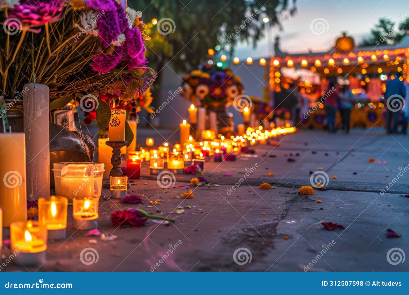 street lined with candles leading to an ofrenda at dusk