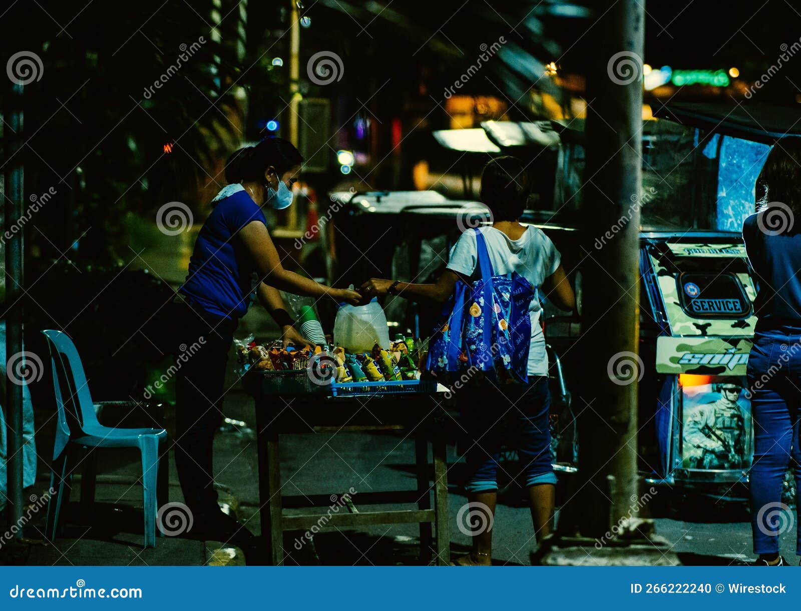 Street Vendor in the Philippines at Night with People Gathered Around
