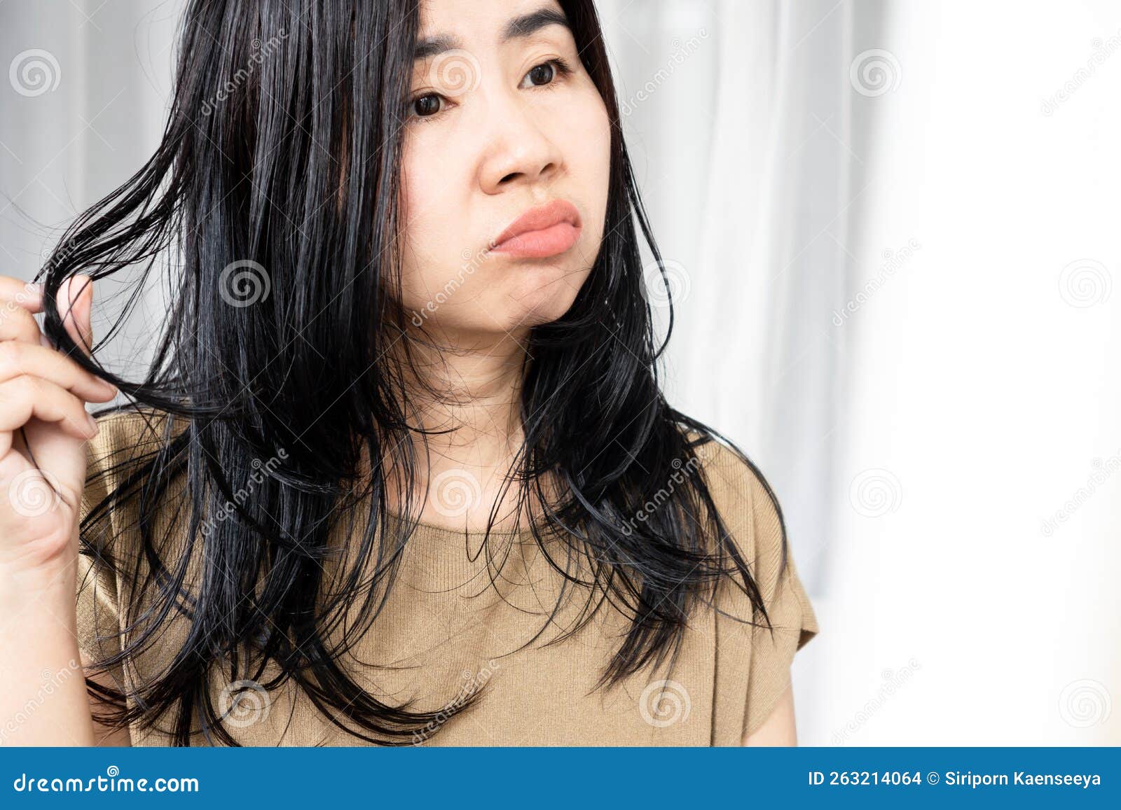 asian woman have problems with oily hair and thinning hair looking at the mirro