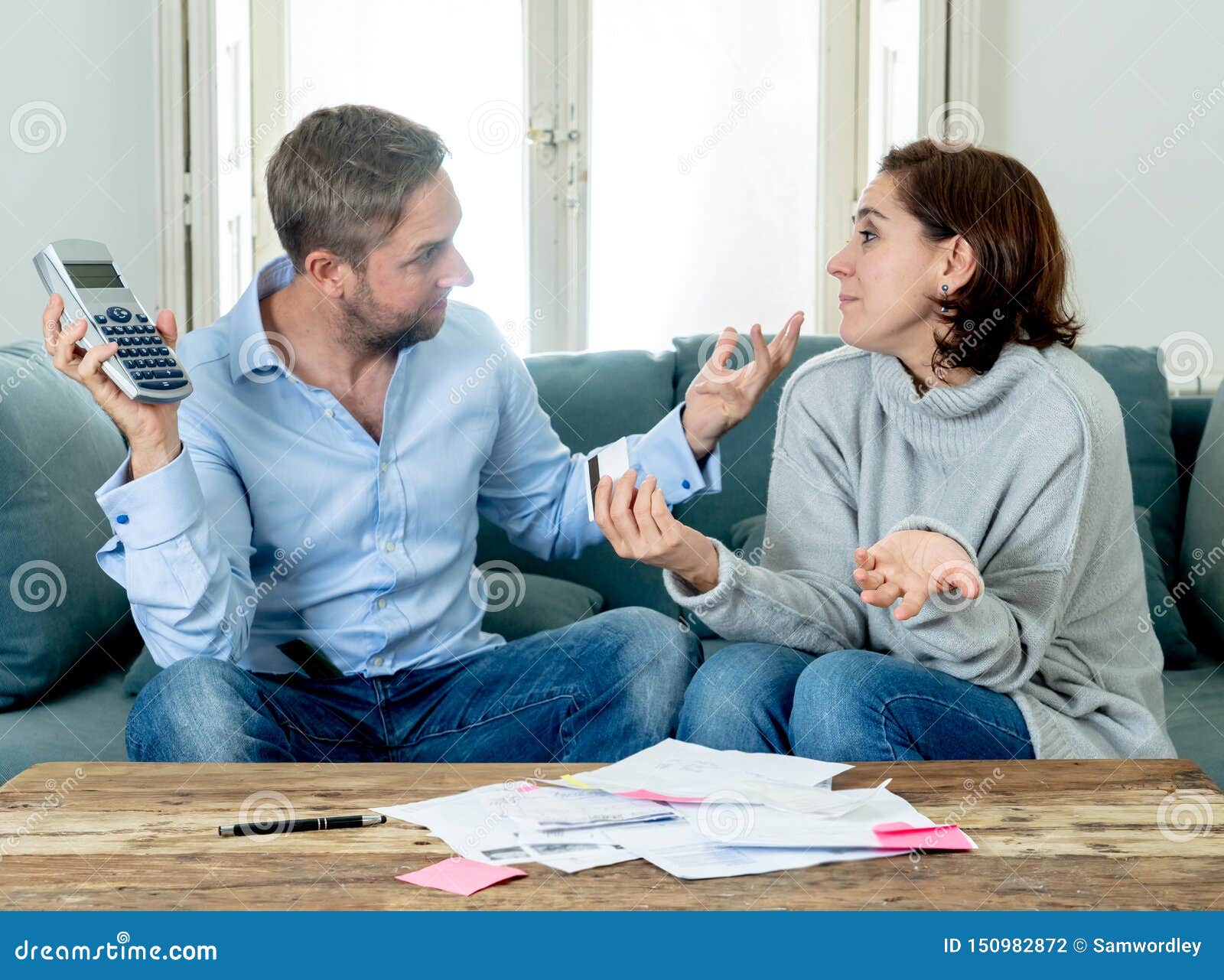 stressed young couple having an argument over credit car debts payments and home finance