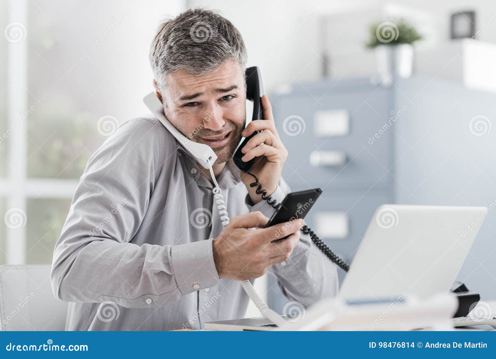 stressed businessman having multiple calls