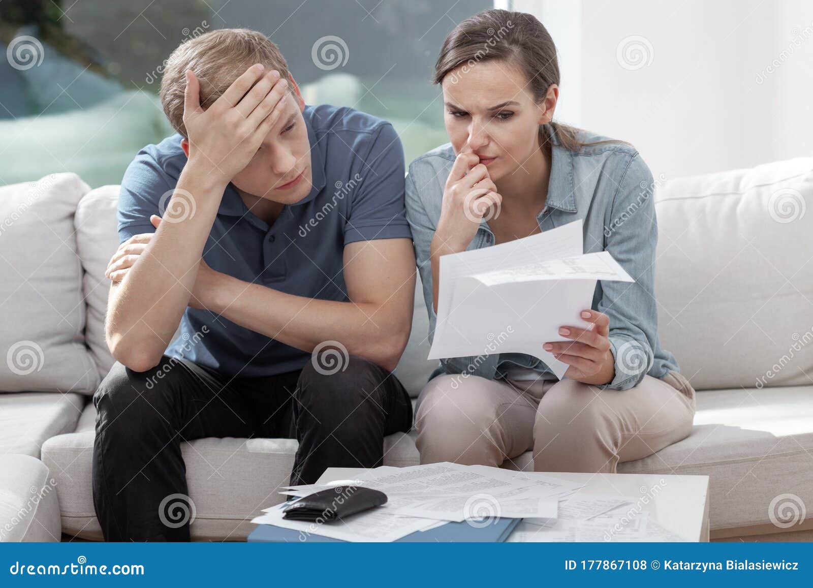 married couple looking frustrated, having no money to pay off their debts, managing family budget together