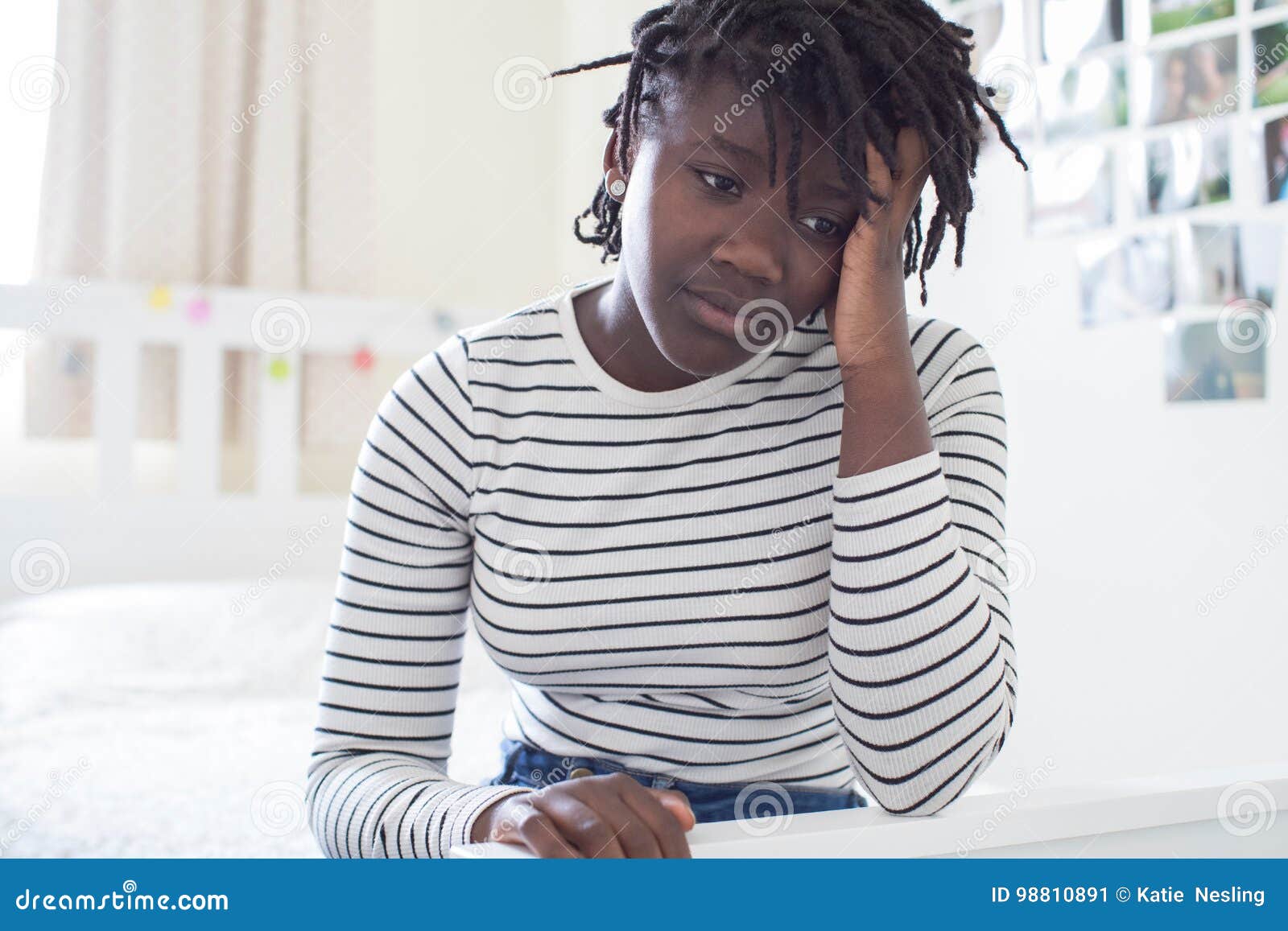 stressed teenage girl sitting in bedroom at home