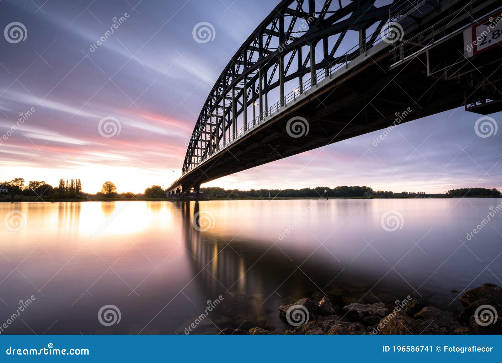 striking arch bridge spans the river during the sunrise