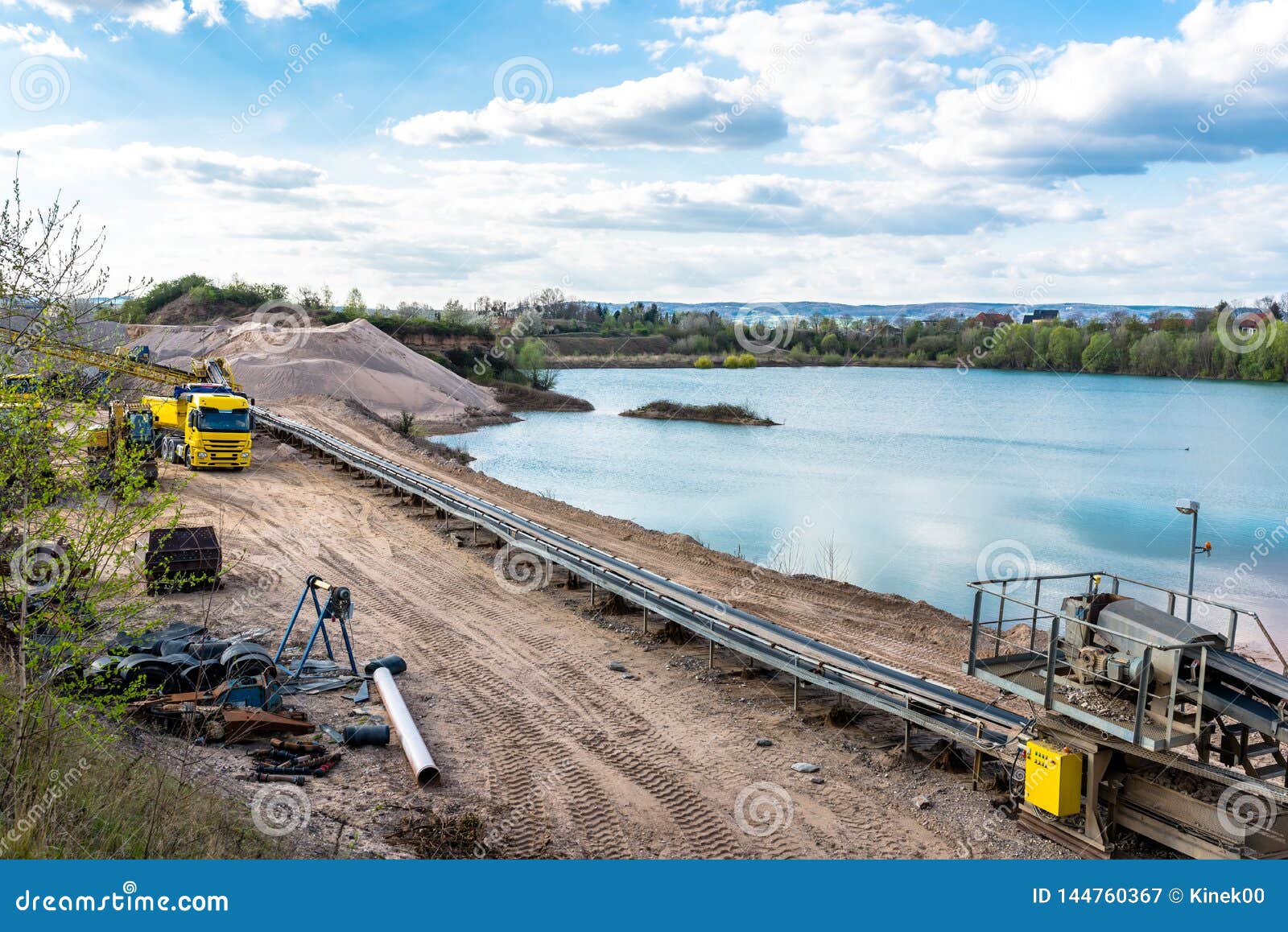 a string of transport belting in a gravel pit for transporting gravel and sand over long distances, belts go along the lake.