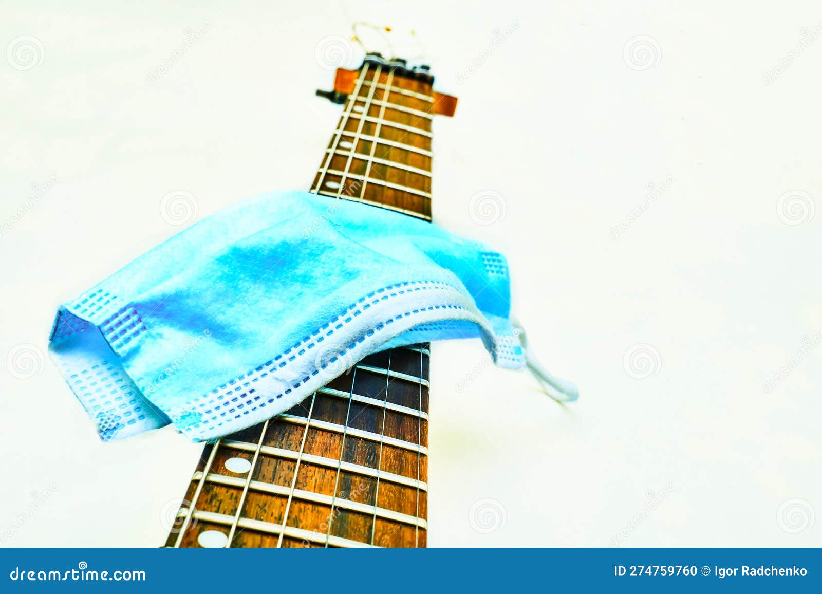 blue protective mask on the fretboard of a black electric guitar