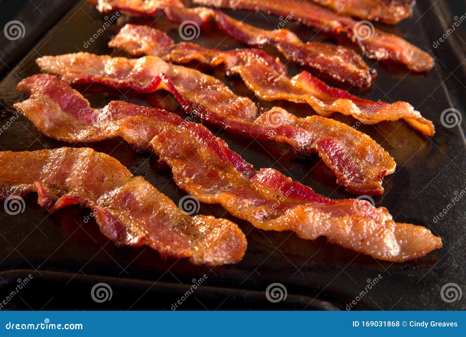 strips of crispy bacon on cast iron pan