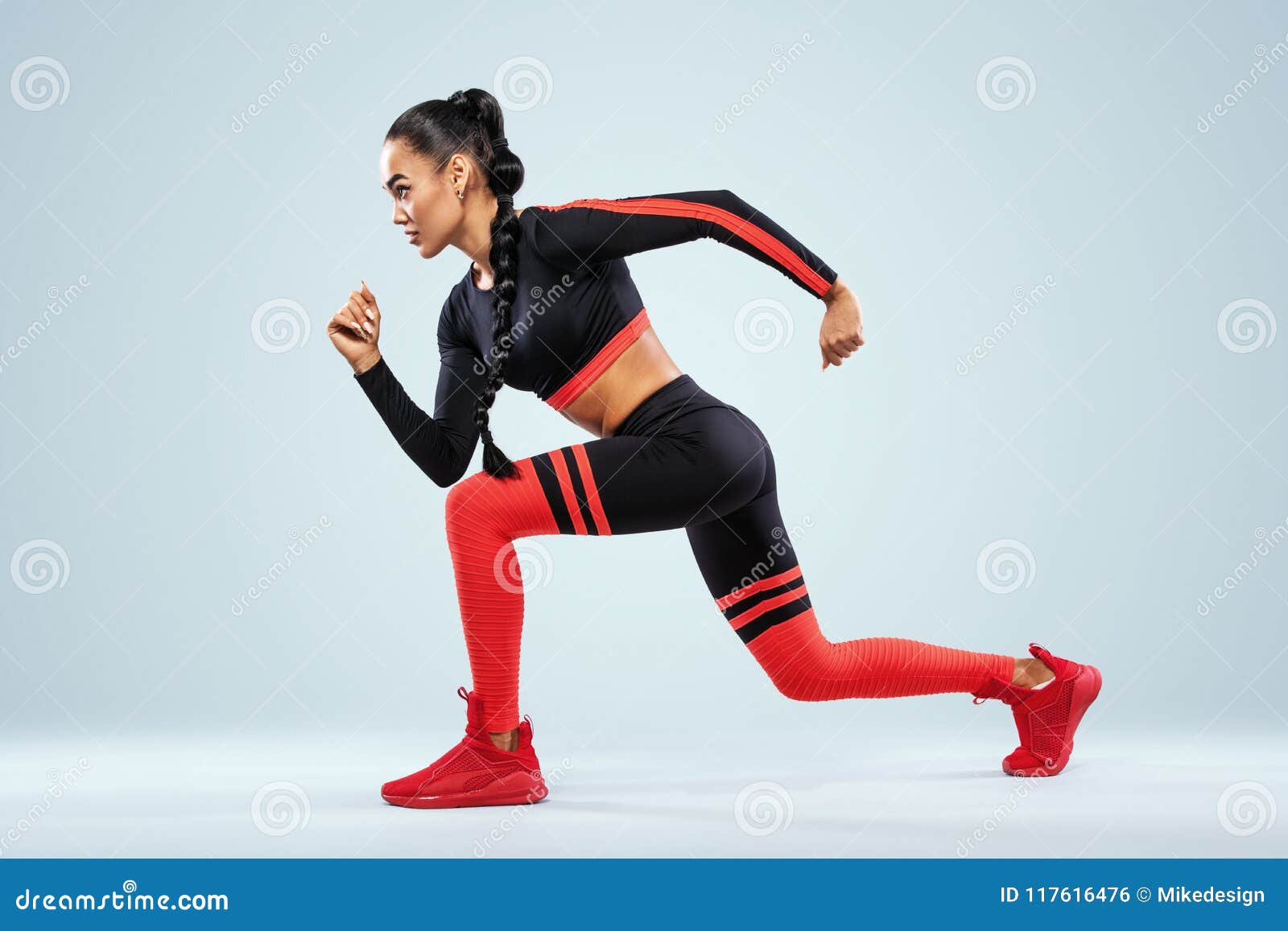 A strong athletic, women sprinter, running on dark background
