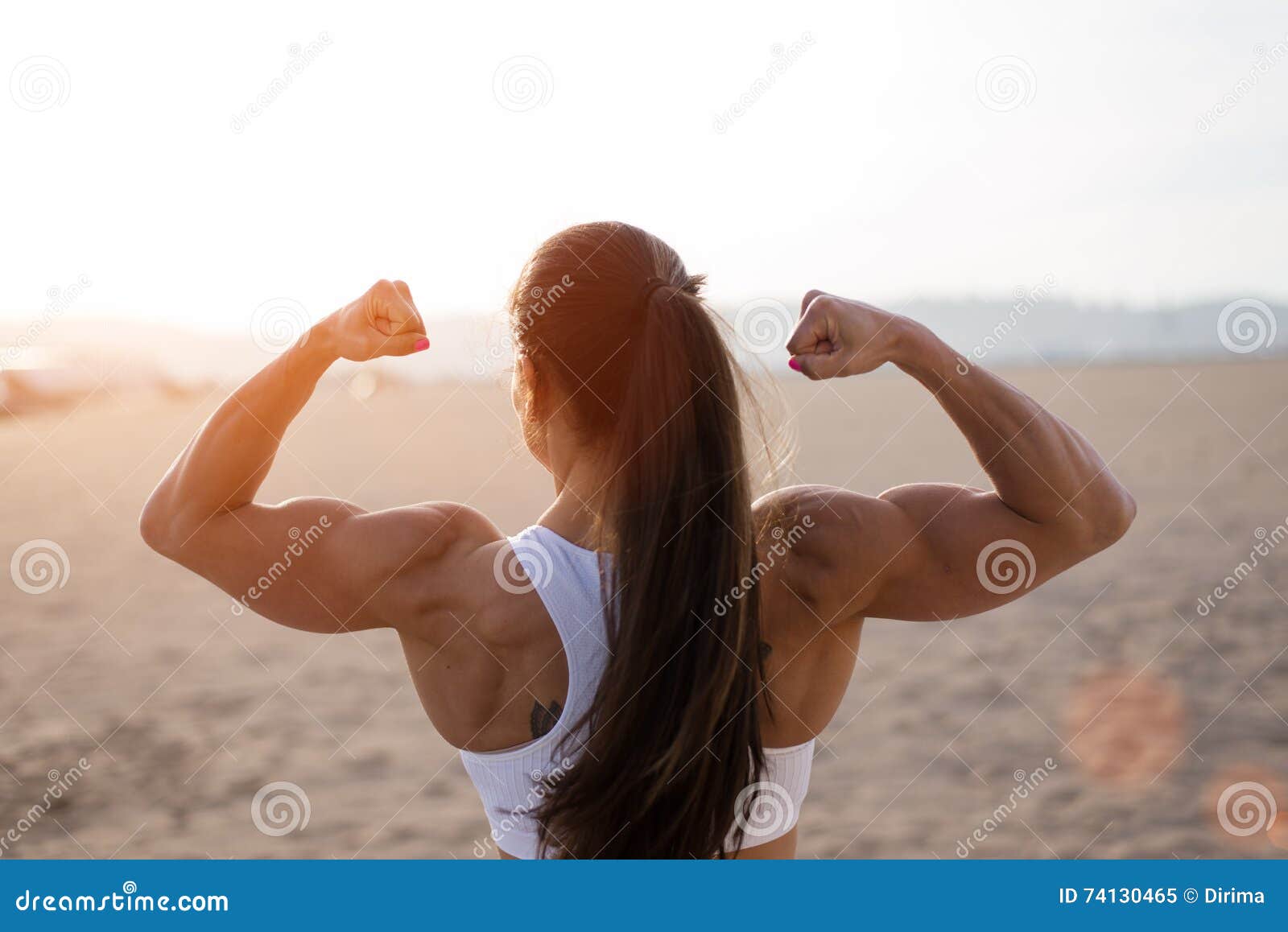 A Strong Girl With Big Muscular Arms On A Beach Stock Photo, Picture and  Royalty Free Image. Image 18043673.