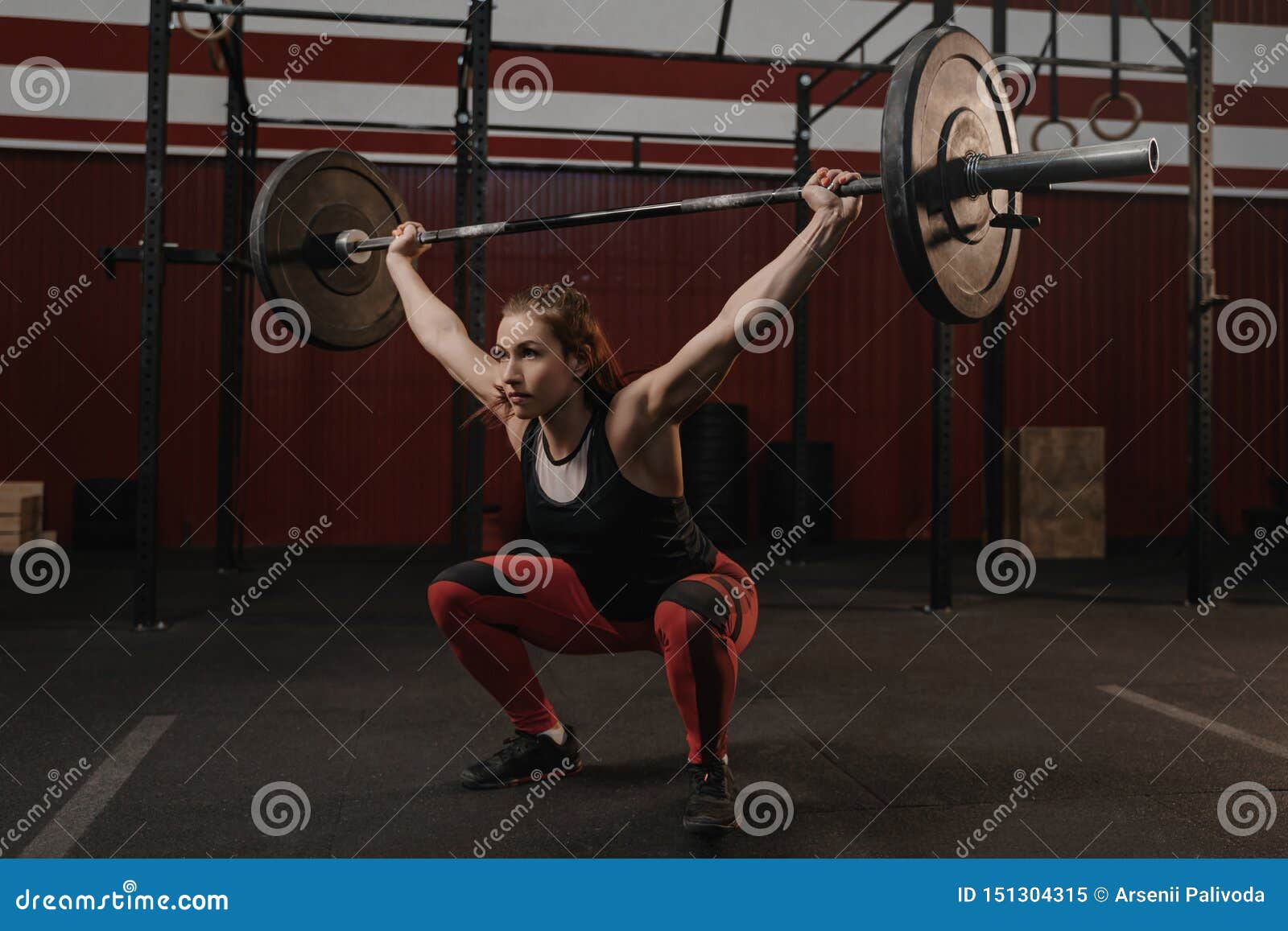 Strong Sports Woman Doing Squats with Heavy Barbell Overhead at the ...