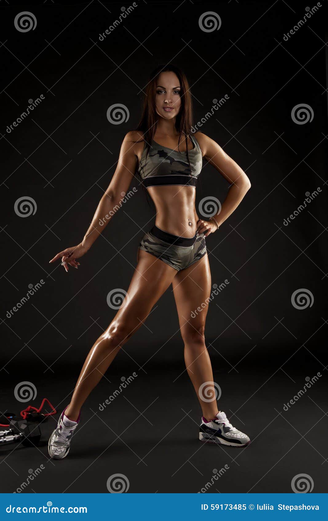 Strong Tanned Beautiful Sports Girl on a Black Background. Stock