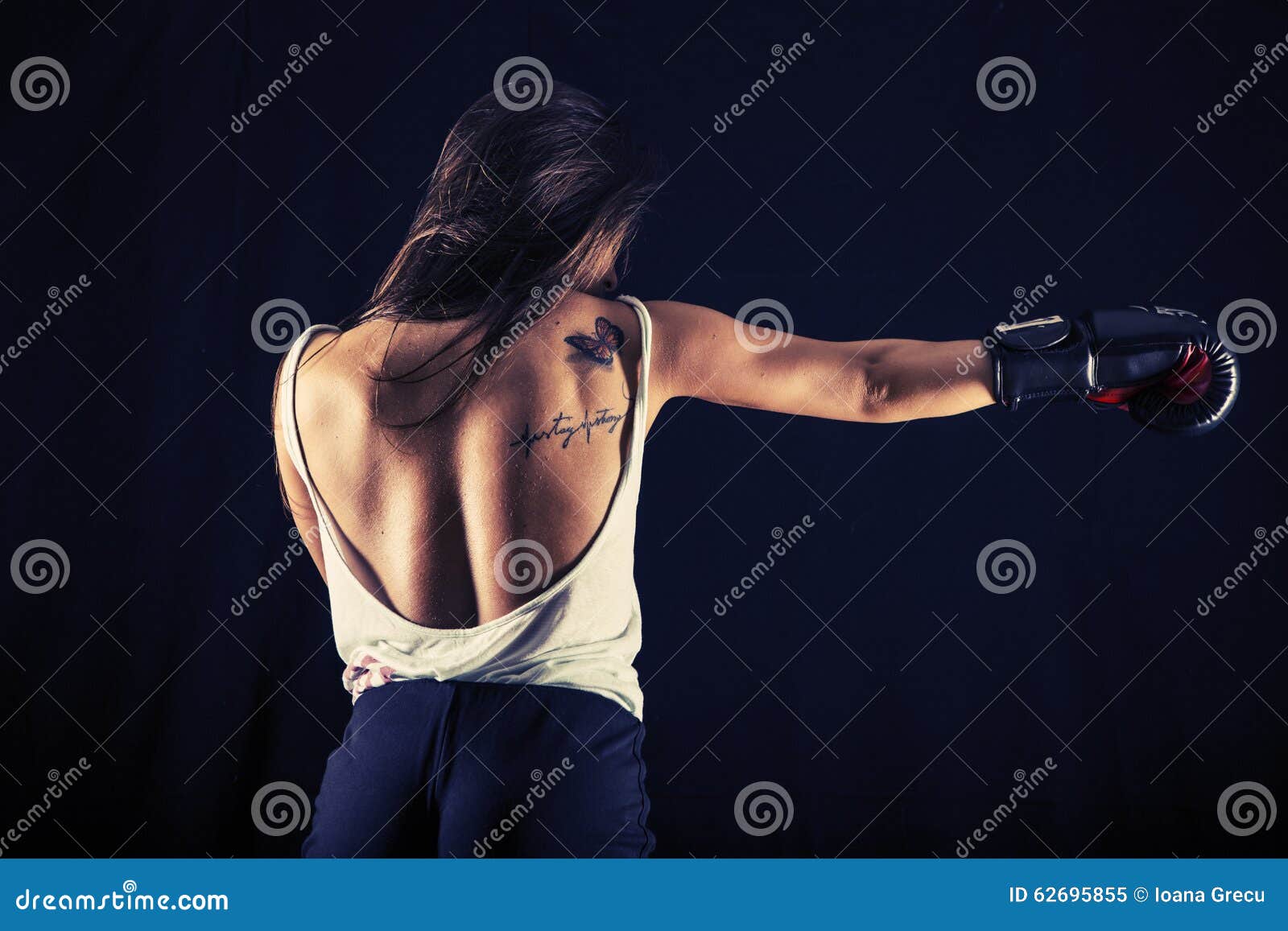 strong young woman boxing performing a jab kick