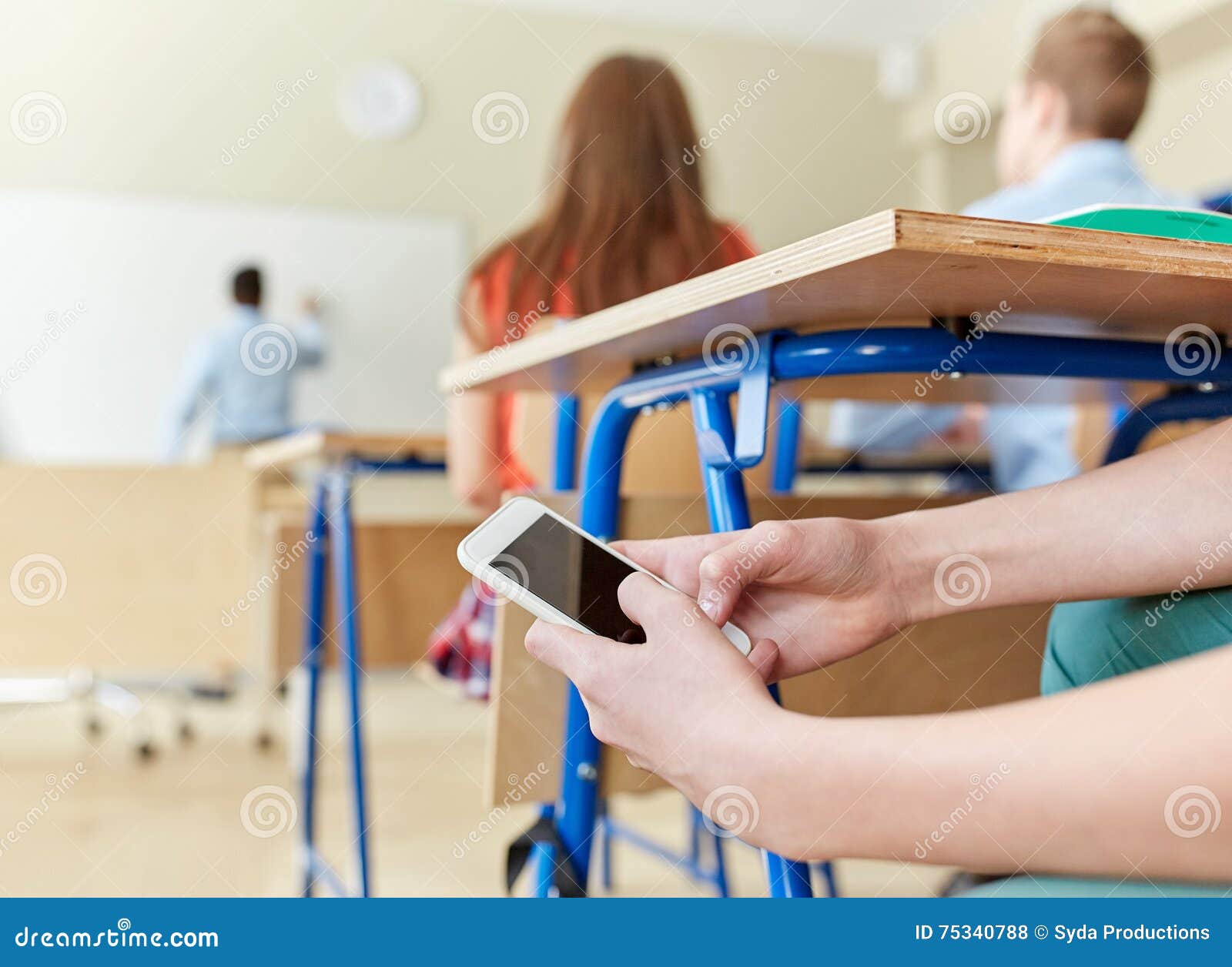 student boy with smartphone texting at school