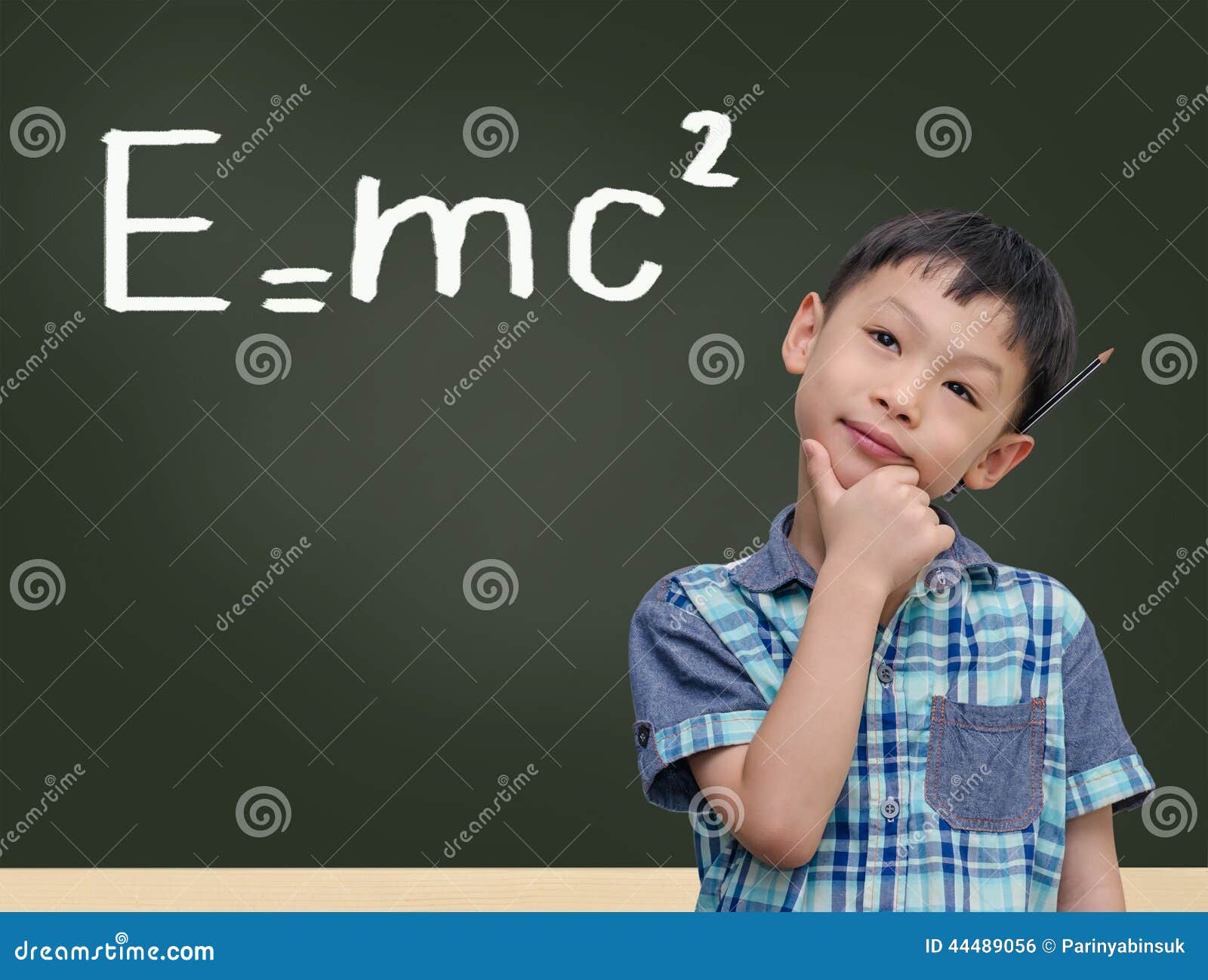 student by chalkboard with e=mc2