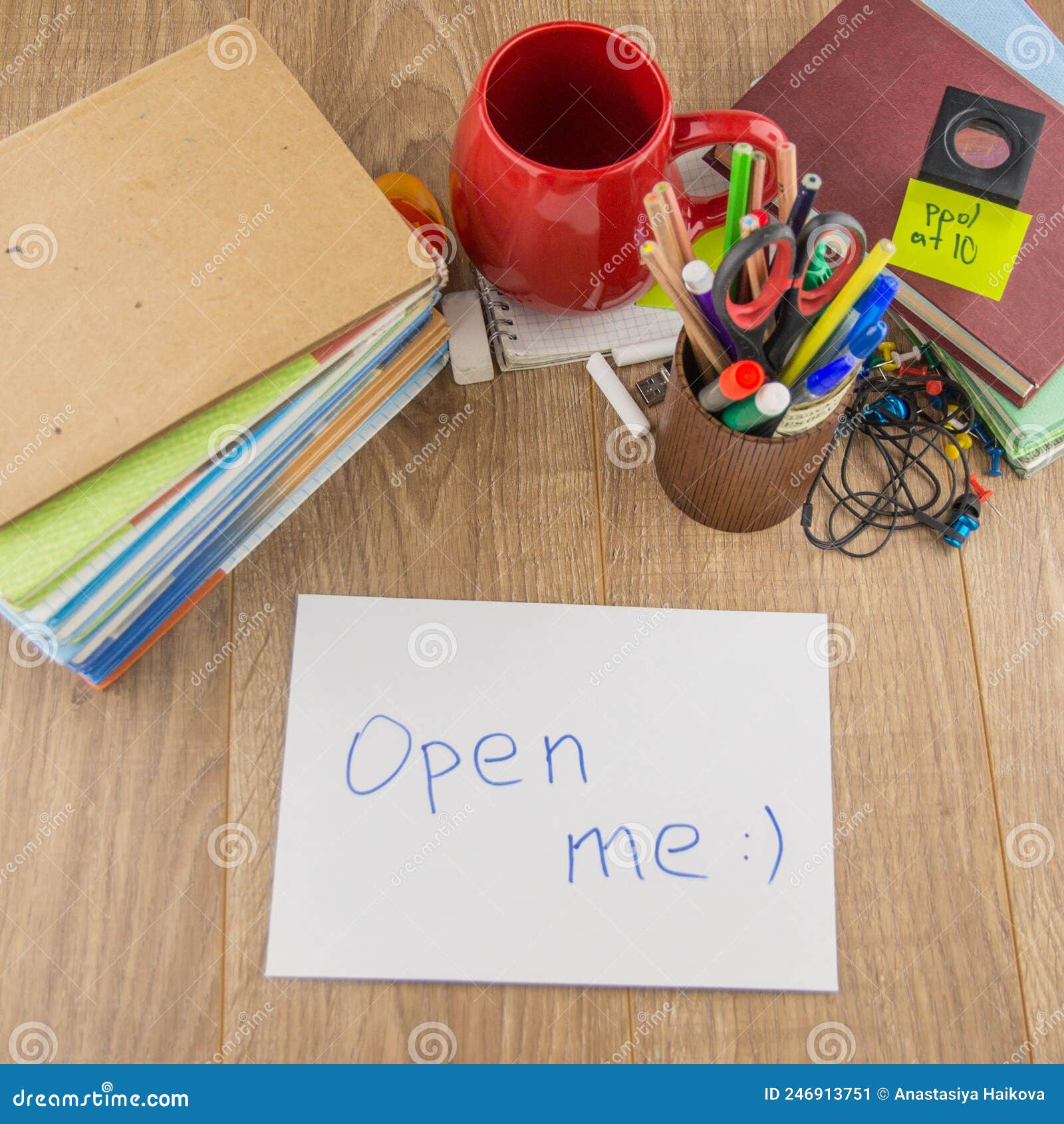 student desktop, pile of books, accessories, stationery. in the forum is an envelope bearing the words