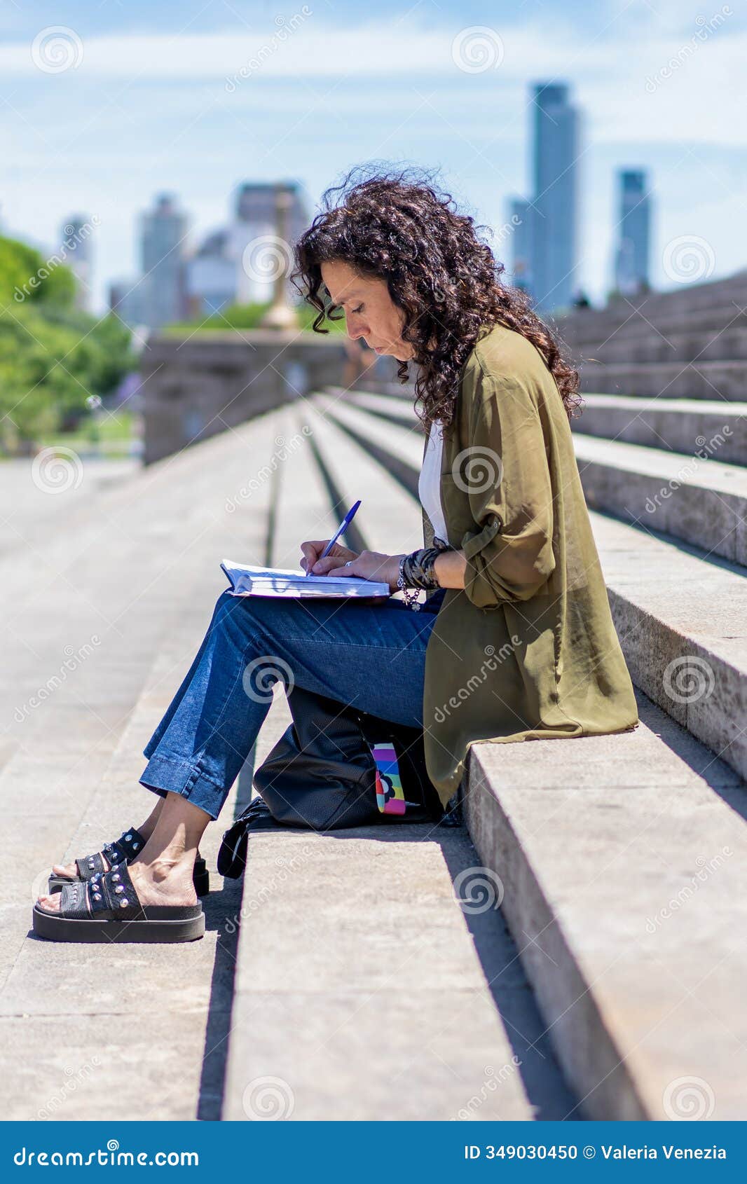 student drawing in her notebook on university steps