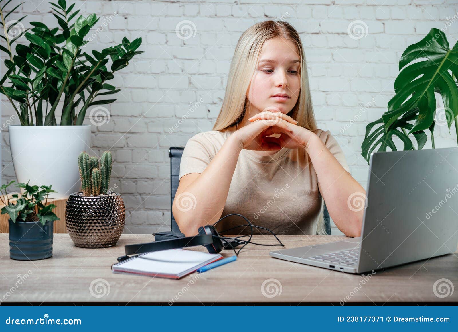 student girl in headphones watching online video zoom class webinar in virtural classroom on her laptop